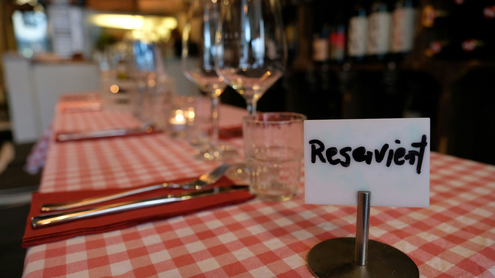 Ein Schild mit der Aufschrift „Reserviert" steht  auf einem Tisch in einem Restaurant