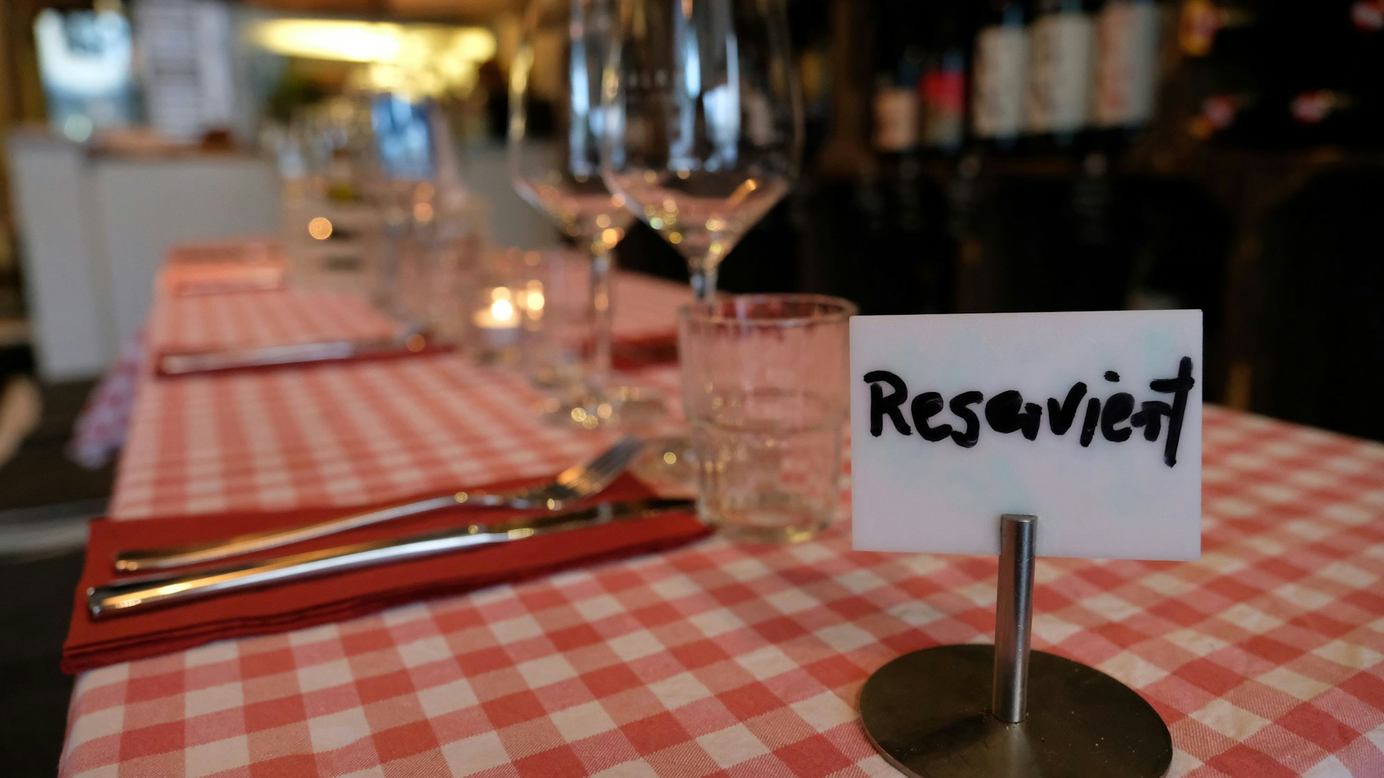 Ein Schild mit der Aufschrift „Reserviert“ steht auf einem Tisch in einem Restaurant. Es handelt sich um ein Symbolbild.