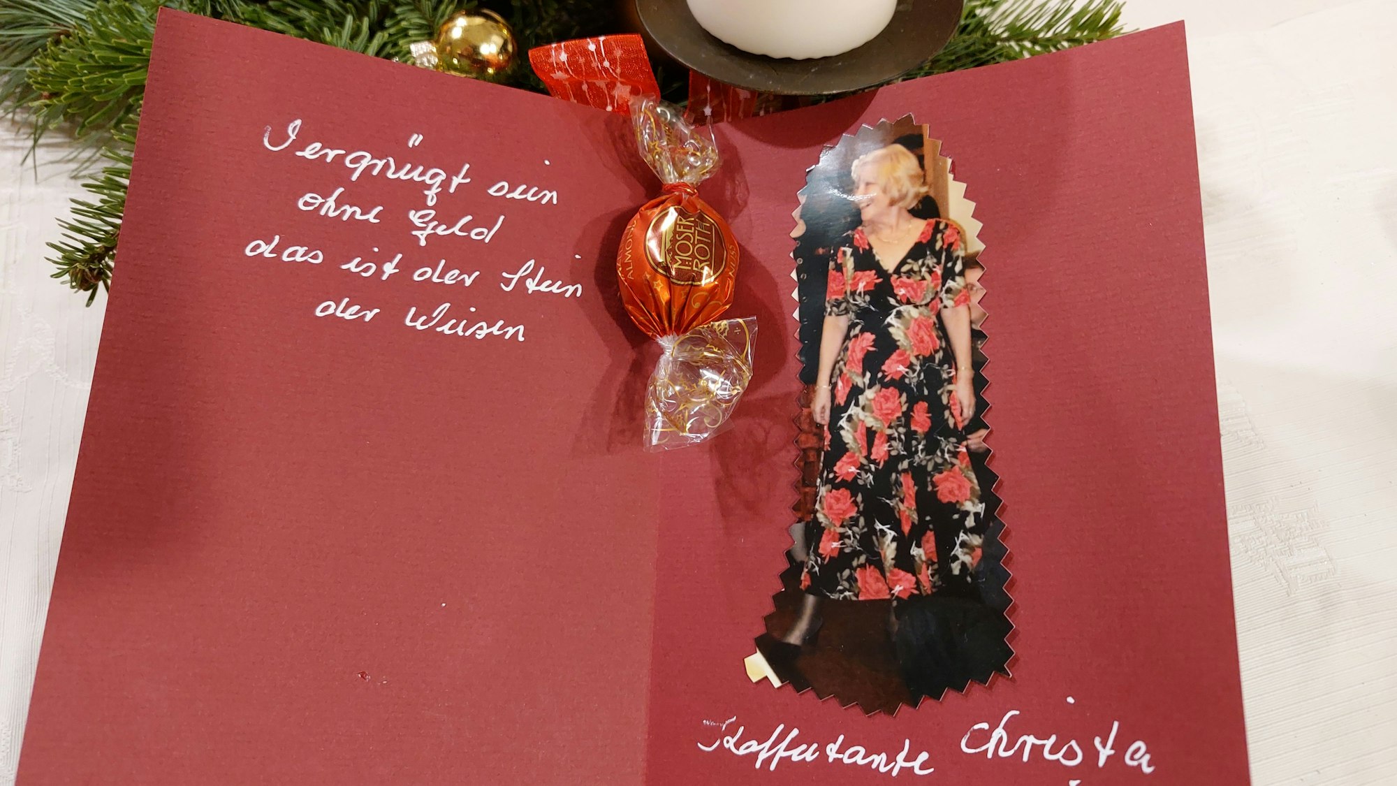 Zum Jubiläum hatte Ruth Klein für jede Kaffeetante eine persönliche Sitzkarte mit einem Foto des jeweiligen Mitglieds gestaltet. Sie ist rot und aufgeklappt und mit einem Spruch in Silber versehen.