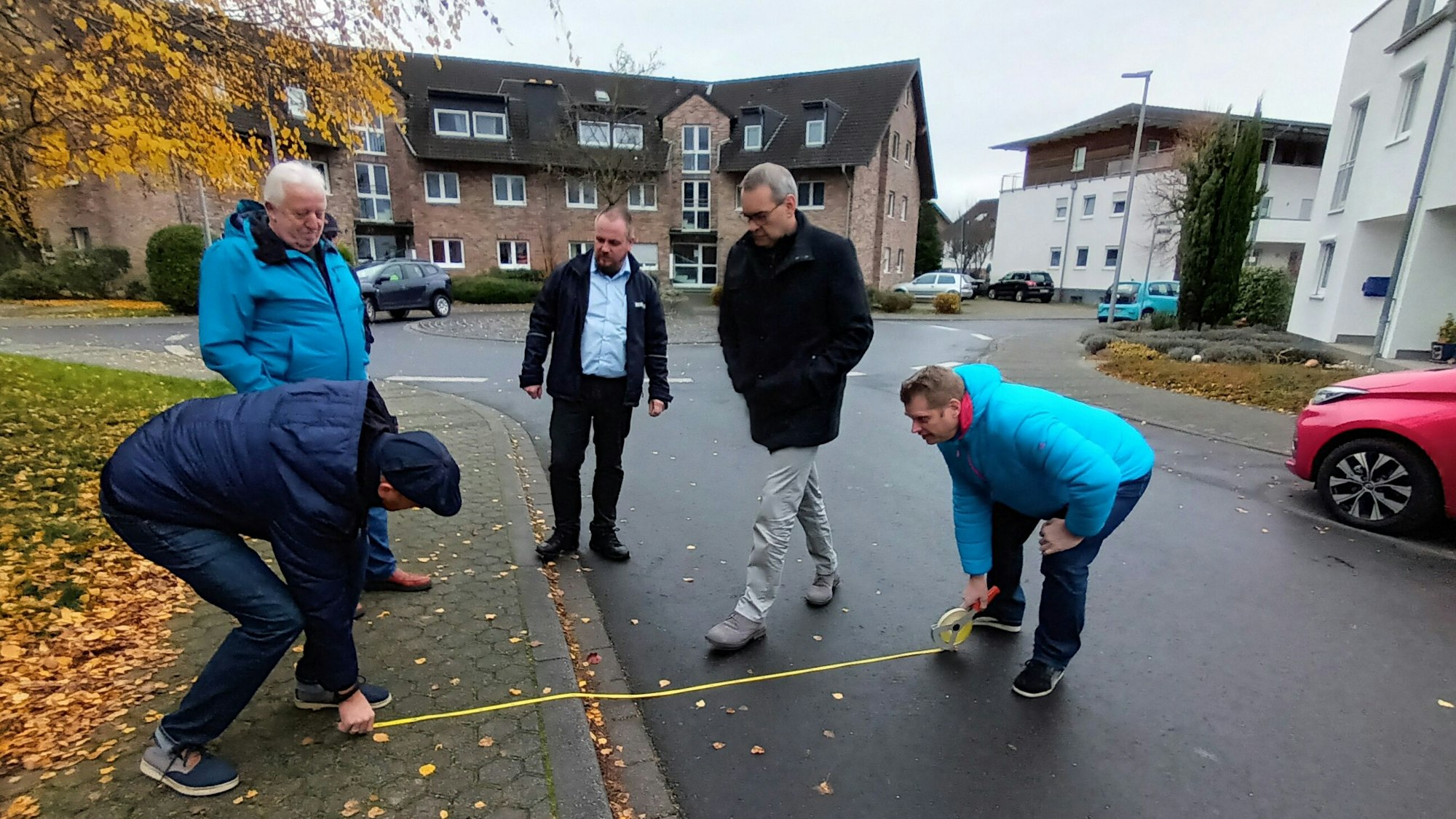 Siegburgs Bürgermeister misst mit Mitarbeitern des Ordnungsamtes den Gehweg und die Fahrbahnbreite aus.