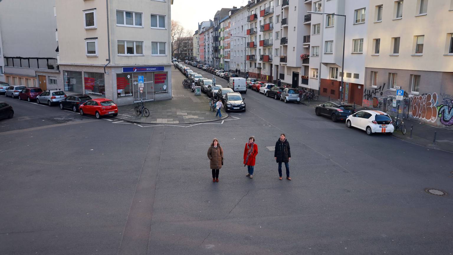 Auf ungenutztem Asphalt stehen Vera Witteck, Sybille Fraquelli und Clara Walther (v.l.) von der IG Winzerveedel.