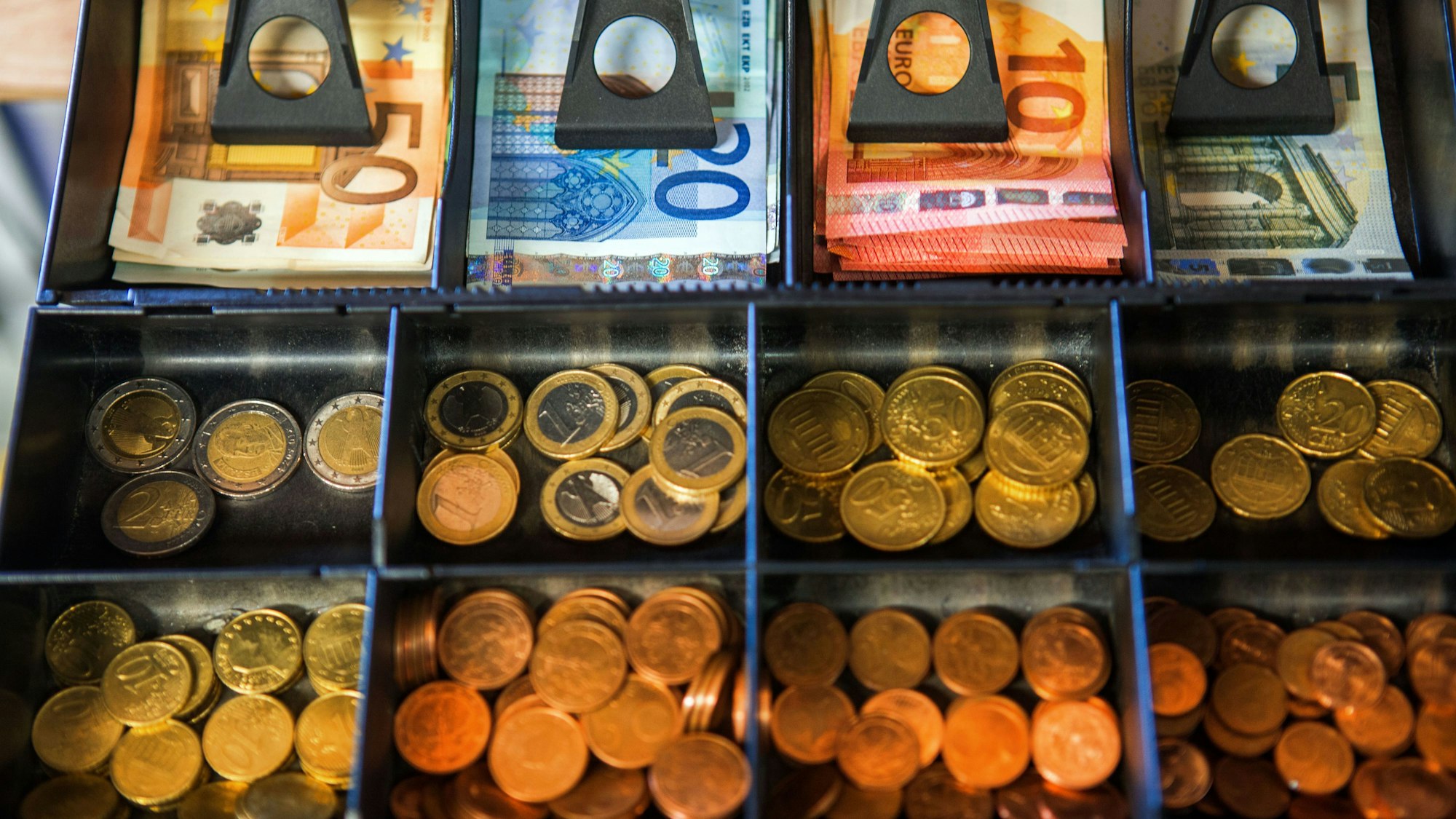 In einer geöffneten Kasse leiegt Bargeld.