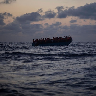 Migrantinnen und Migranten an Bord eines Holzbootes.