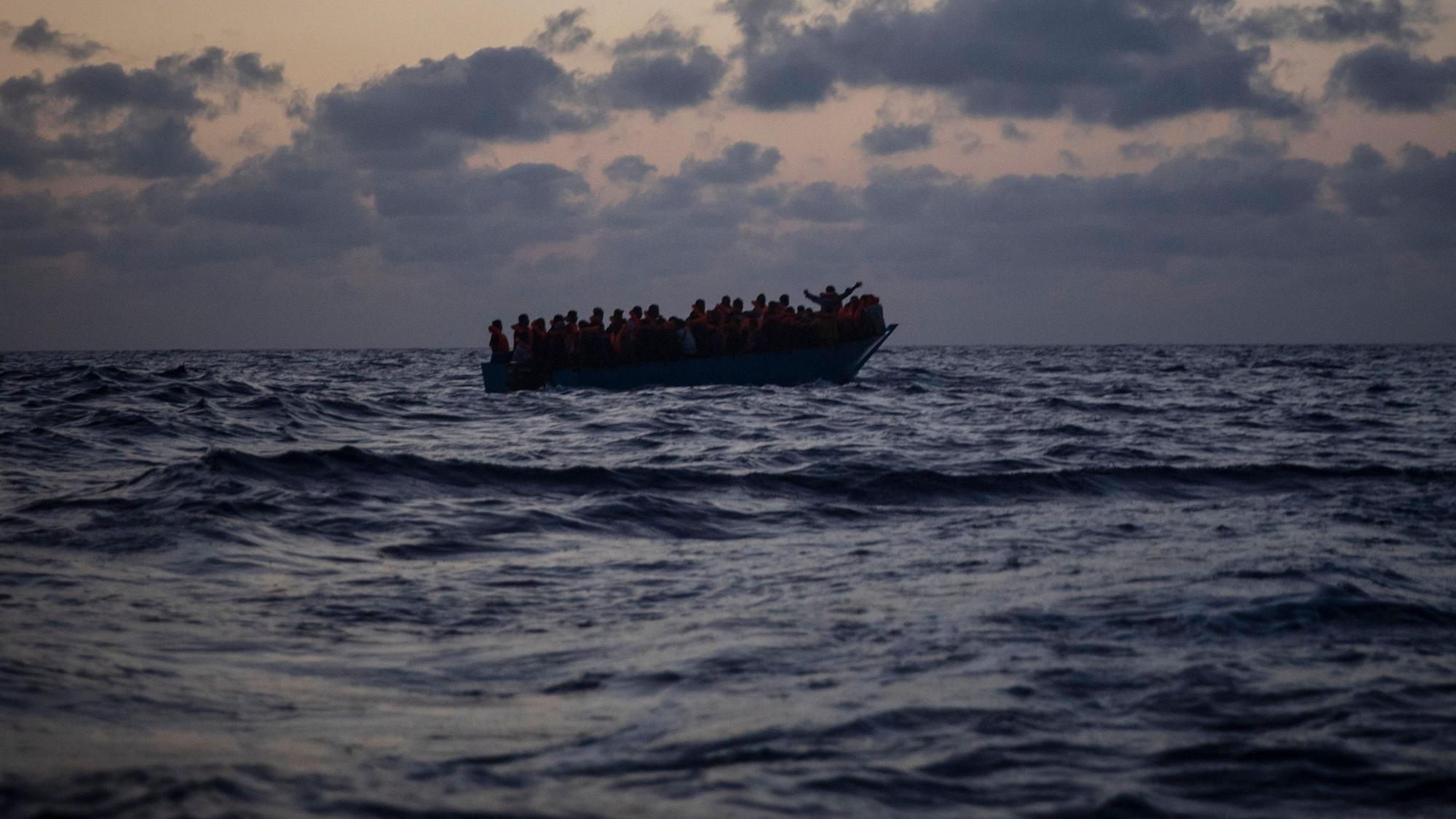 Migrantinnen und Migranten an Bord eines Holzbootes.