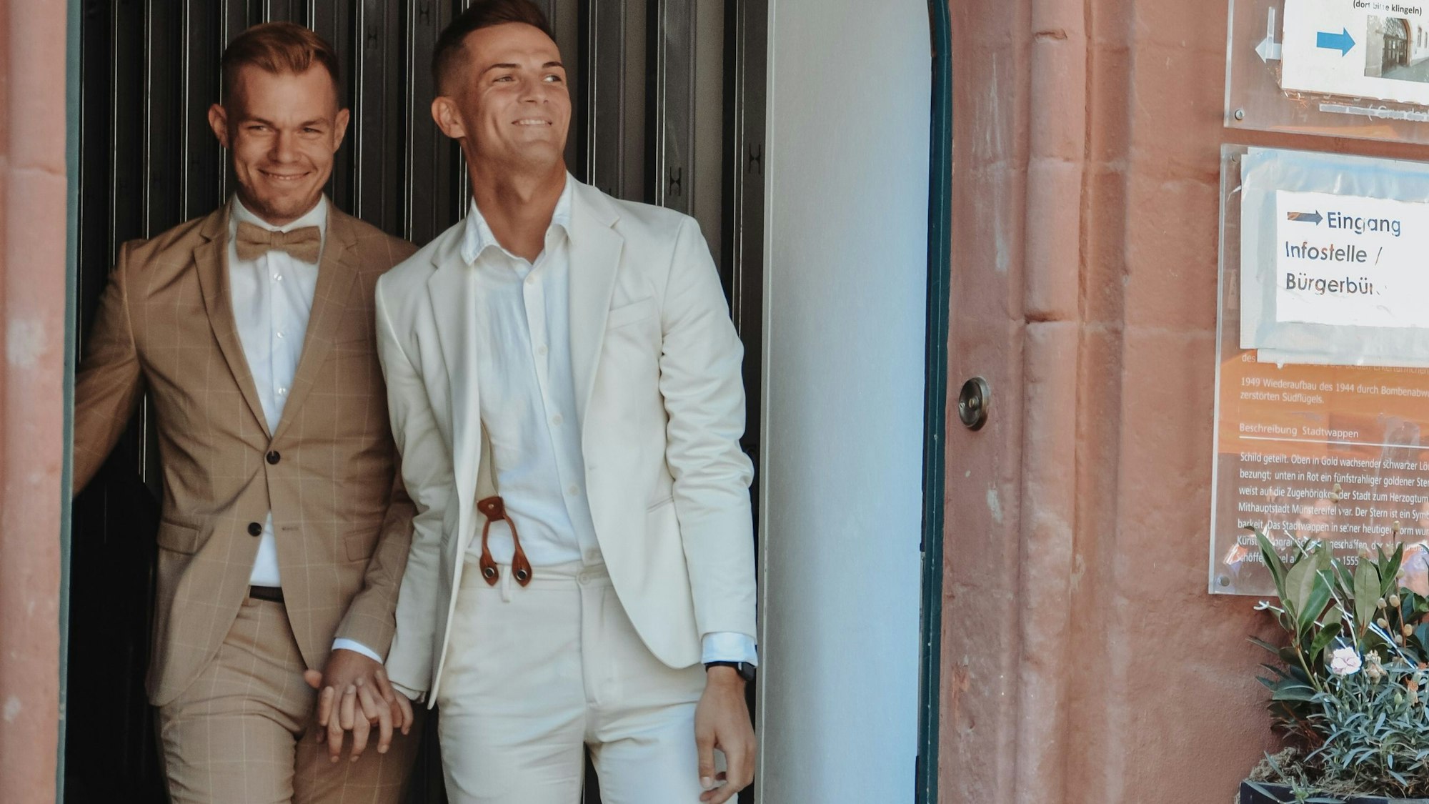 Sascha Hostnik und sein Mann Dennis verlassen nach der Trauung das Rathaus von Bad Münstereifel.