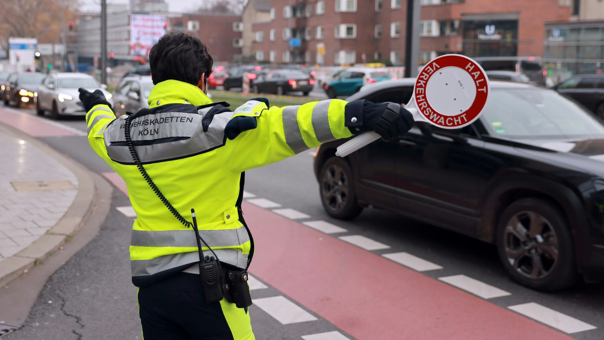 Ein Lotse weist Autofahrern den Weg zu den Parkhäusern: