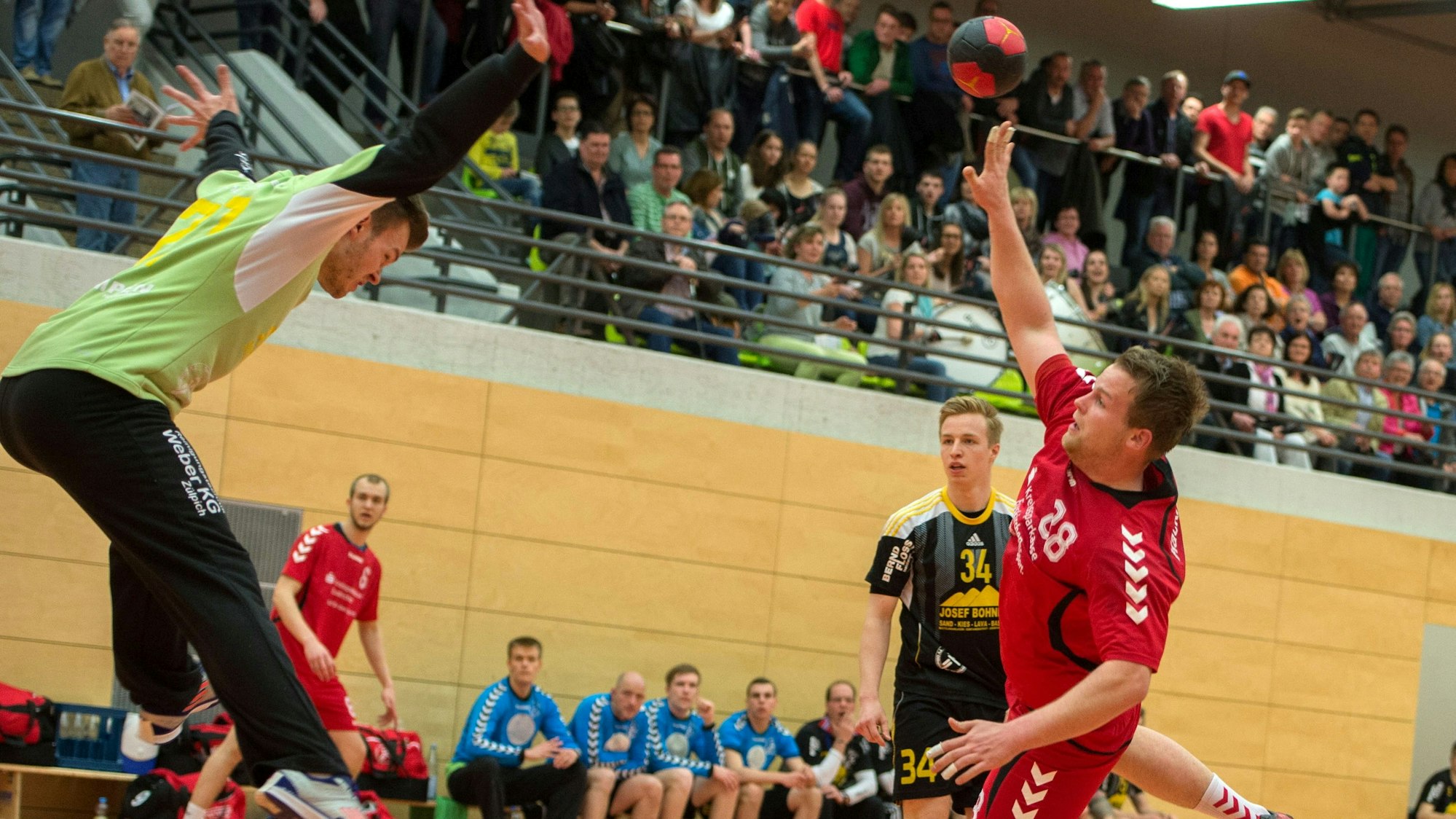 Handballtorwart Sascha Hostnik versucht mit einem Sprung aus dem Tor und versucht so einen Ball zu halten.