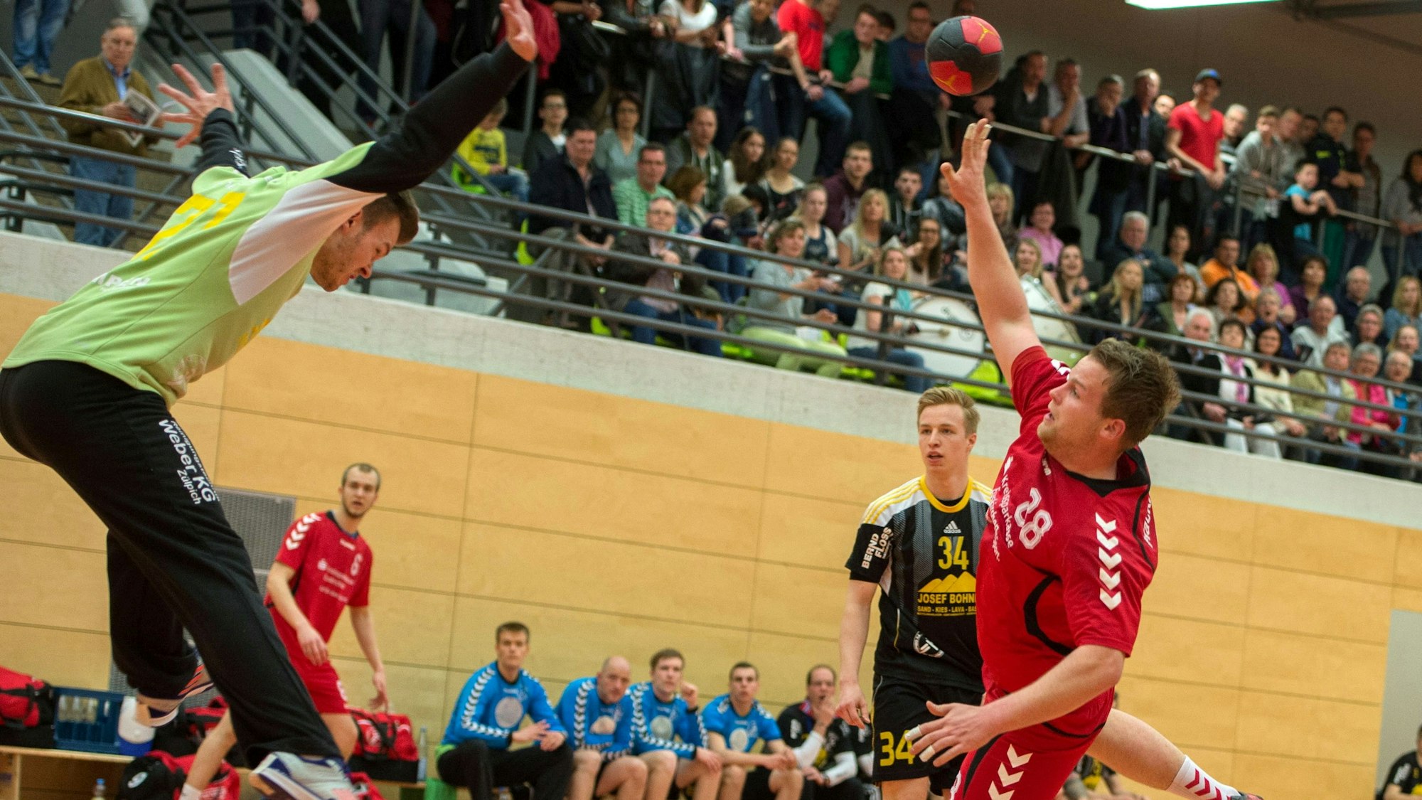 Handballtorwart Sascha Hostnik versucht mit einem Sprung aus dem Tor und versucht so einen Ball zu halten.