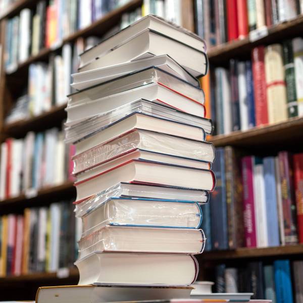 Ein Stapel Bücher liegt auf einem Verkaufstisch in einer Buchhandlung.