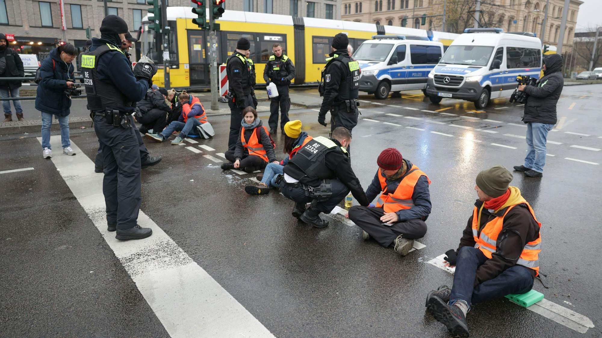 Ein Bild aus der vergangenen Woche: Polizisten lösen die Hand eines Klimaaktivisten vom Asphalt auf der Berliner Invalidenstraße.