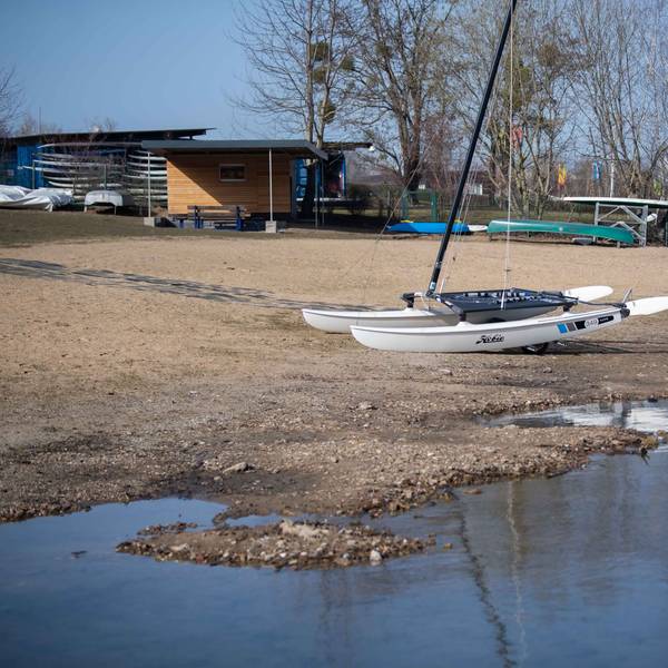 Ein Boot liegt auf dem Trockenen am Rand des Zülpicher Sees. Das Wasser ist zurückgegangen, sodass der Seeboden zu sehen ist.