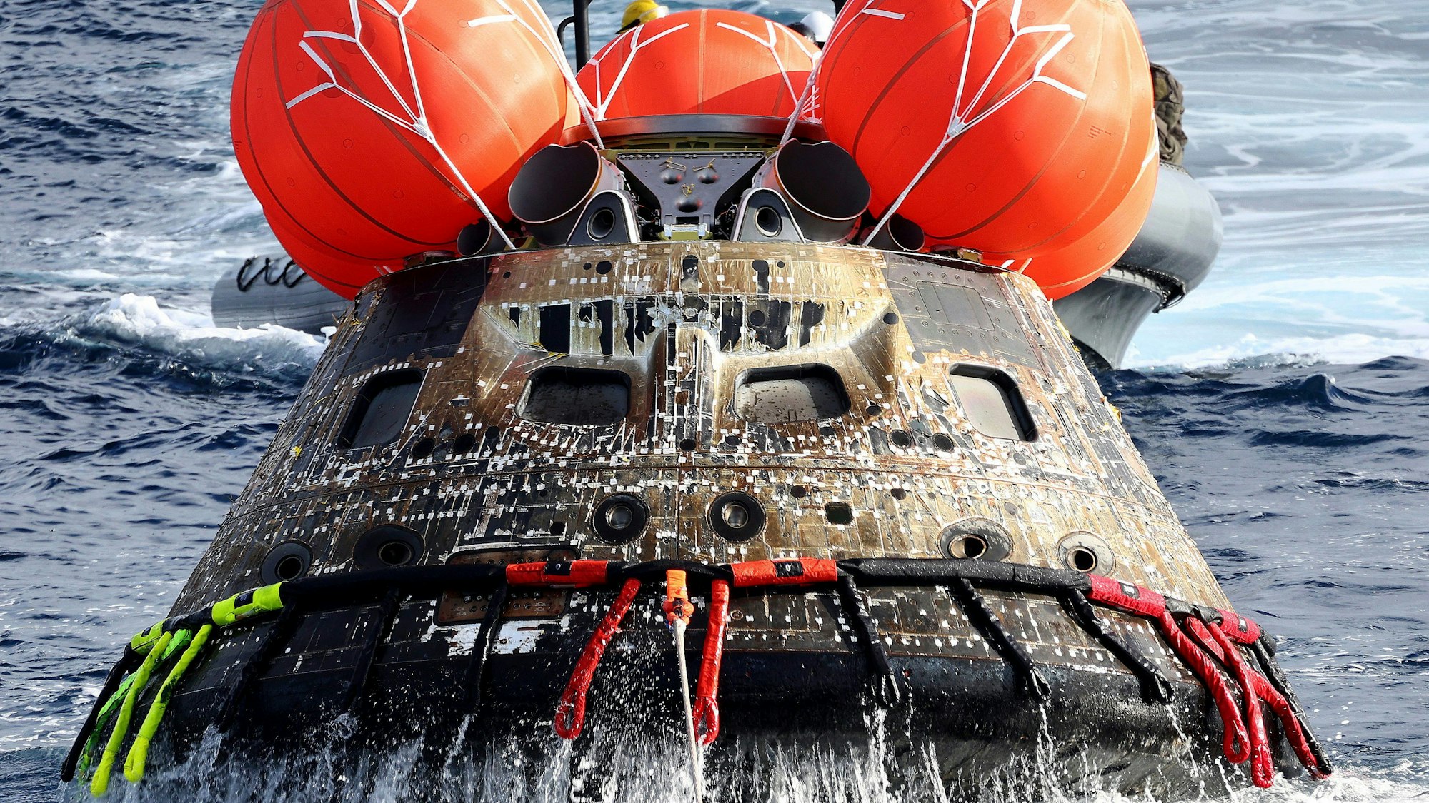 Die Orion-Kapsel der NASA wird auf das Wellendeck der USS Portland gezogen, nachdem sie vor der Küste von Mexiko gelandet ist.