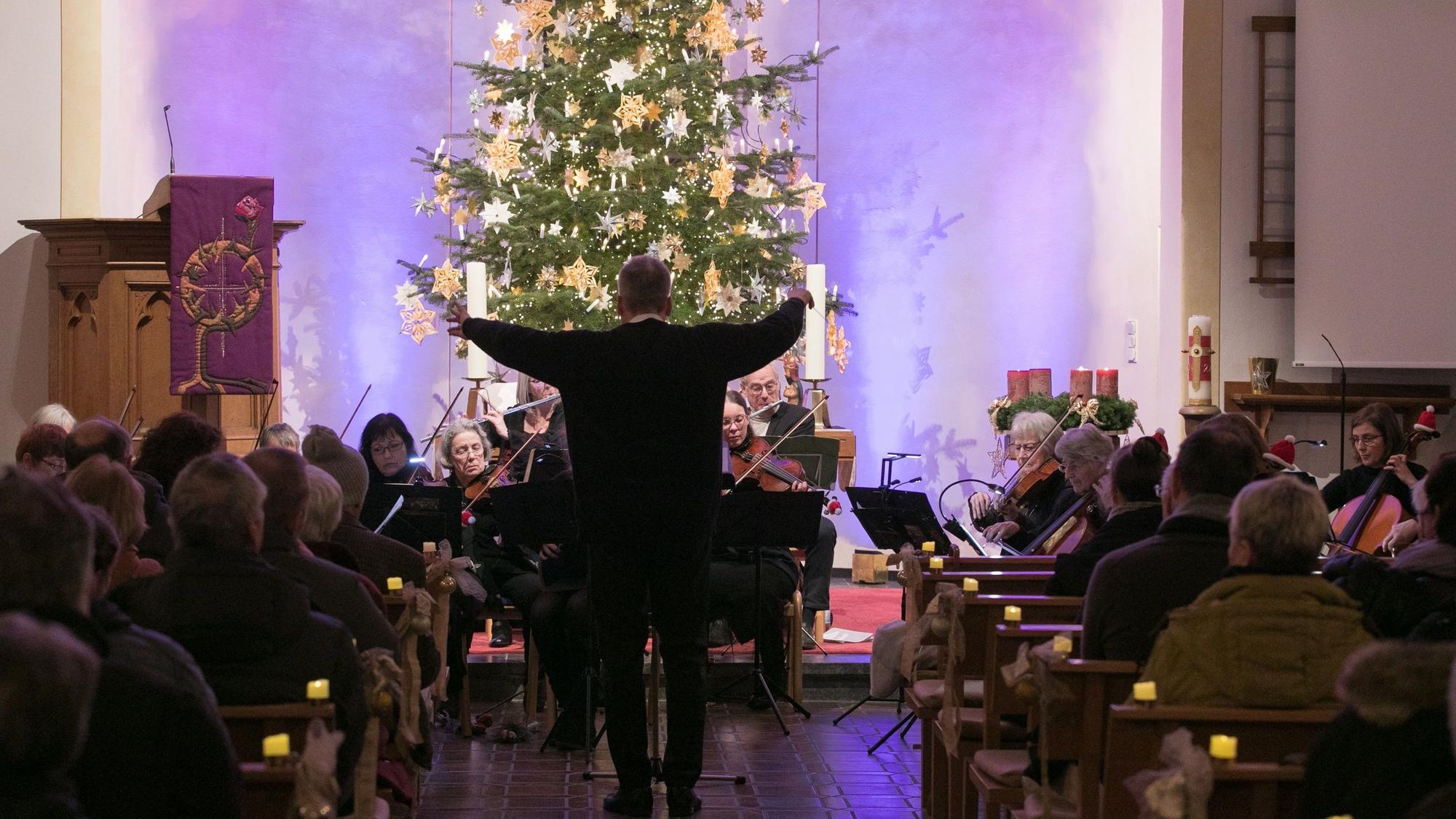 Das Oberbergische Kammerorchester spielt in der evangelischen Kirche in Oberbantenberg. Der Dirigent steht in Richtung eines großen Weihnachtsbaums.