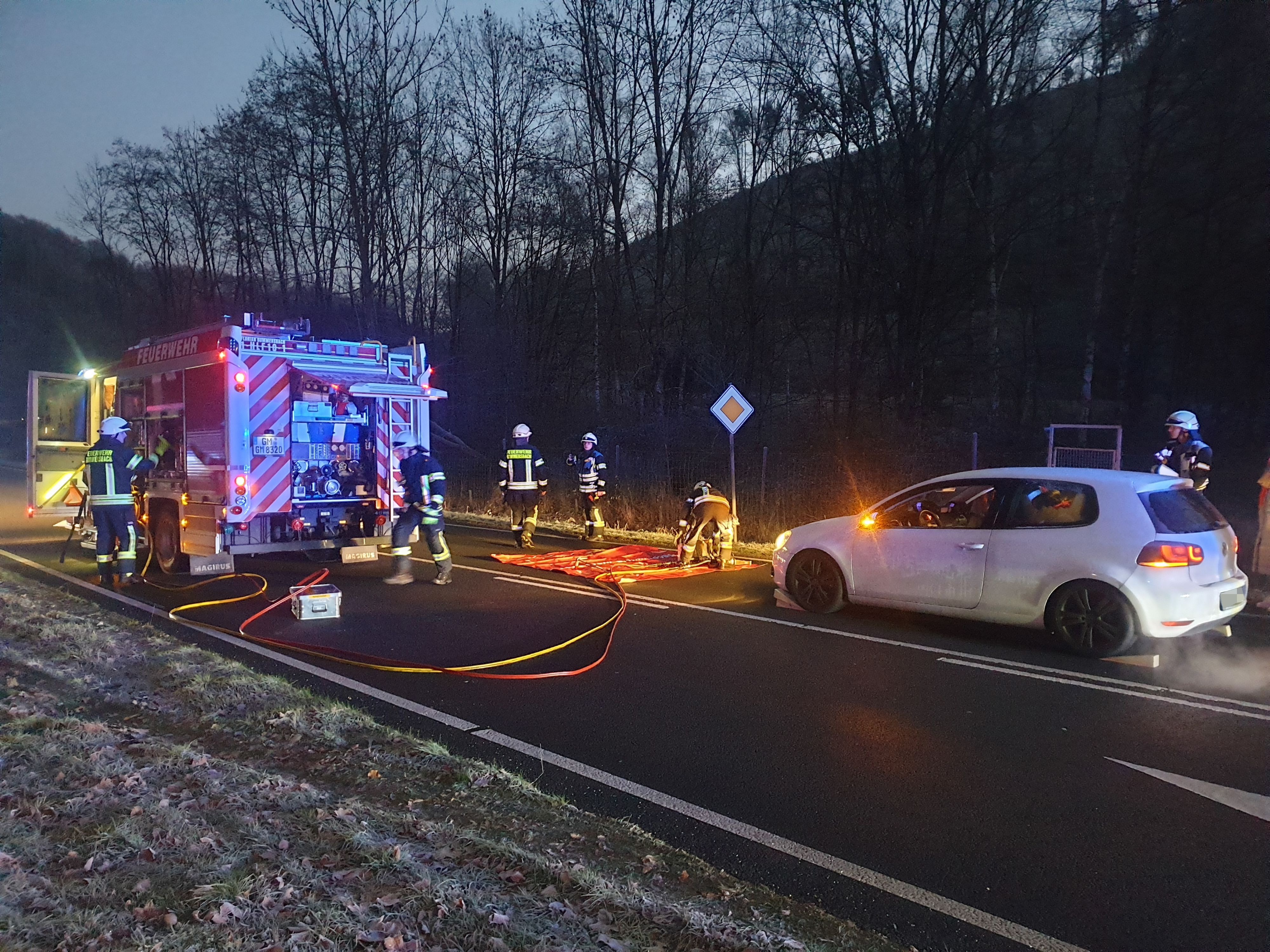 Ein Auto steht auf der Straße, davor ein Feuerwehrauto.