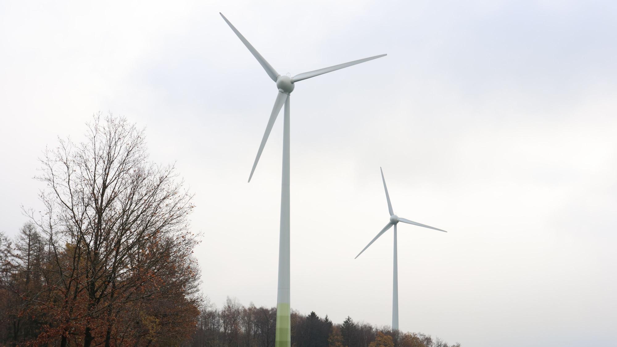 Oberhalb der Ortschaft Wendershagen in Morsbach stehen auf den Wiesen zwei Windräder.