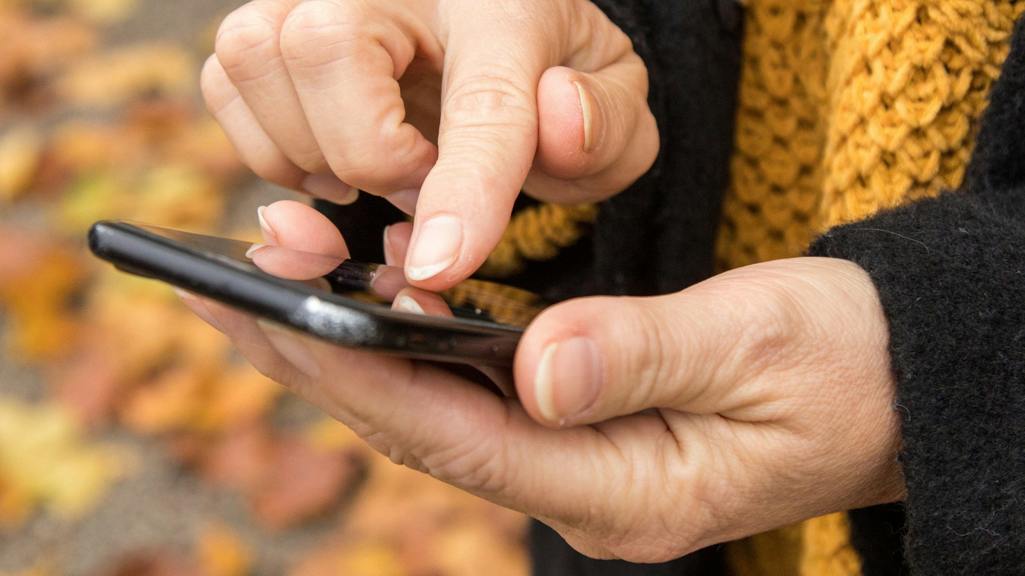 Das Foto zeigt Frauenhände, die ein Handy bedienen. Auch über das mobile Telefon lassen sich E-Mails abrufen.