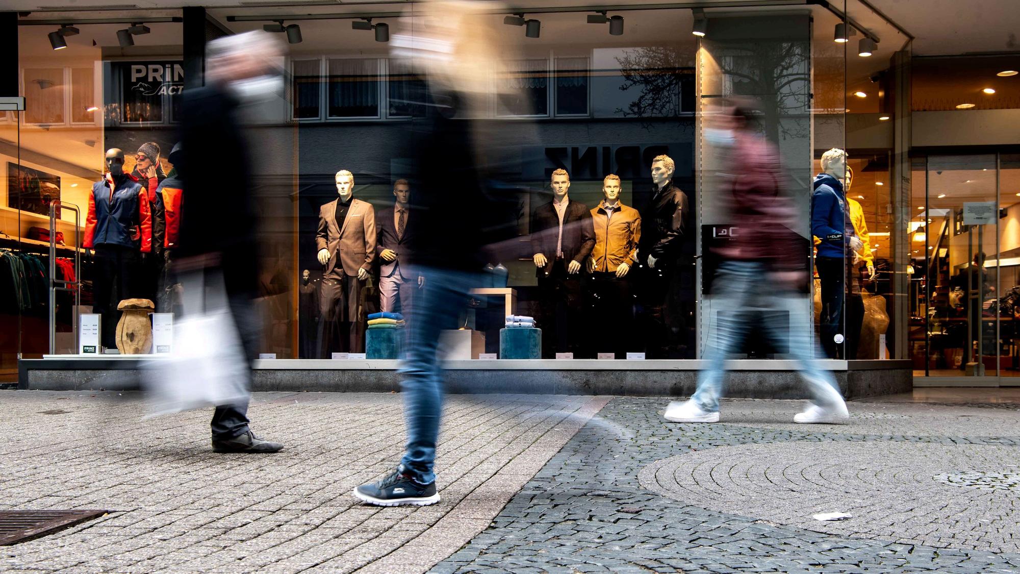 Das Bild zeigt die Fußgängerzone von Euskirchen. Drei Passanten schlendern durch die Innenstadt.