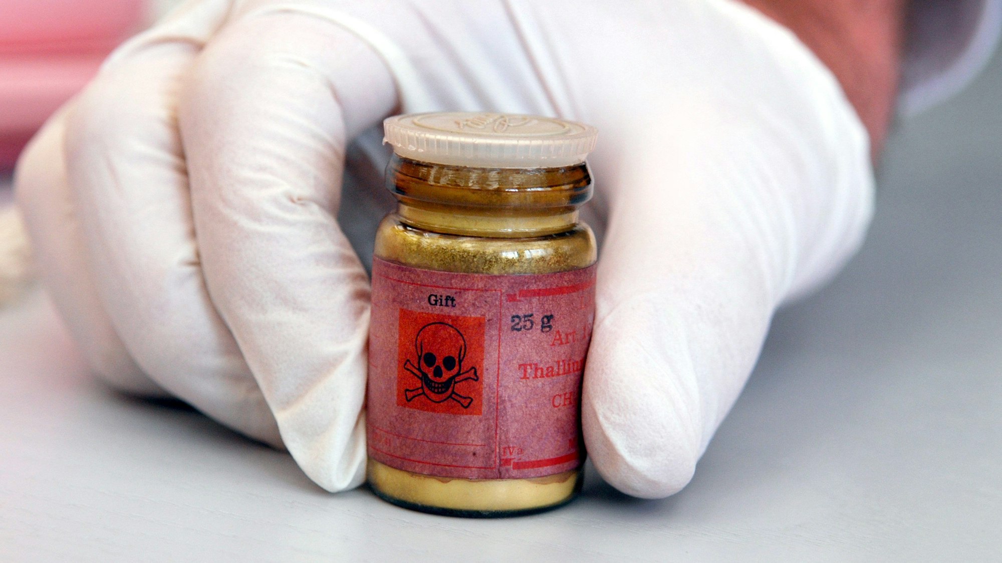 Eine Flasche mit Rattengift aus Thallium, markiert mit einem Totenkopfsymbol auf dem roten Etikett.