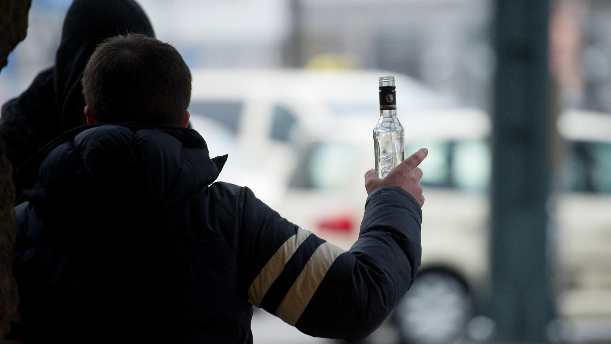 Ein stark alkoholisierter Mann gestikuliert mit einer Wodkaflasche in der Hand. (Symbolbild)