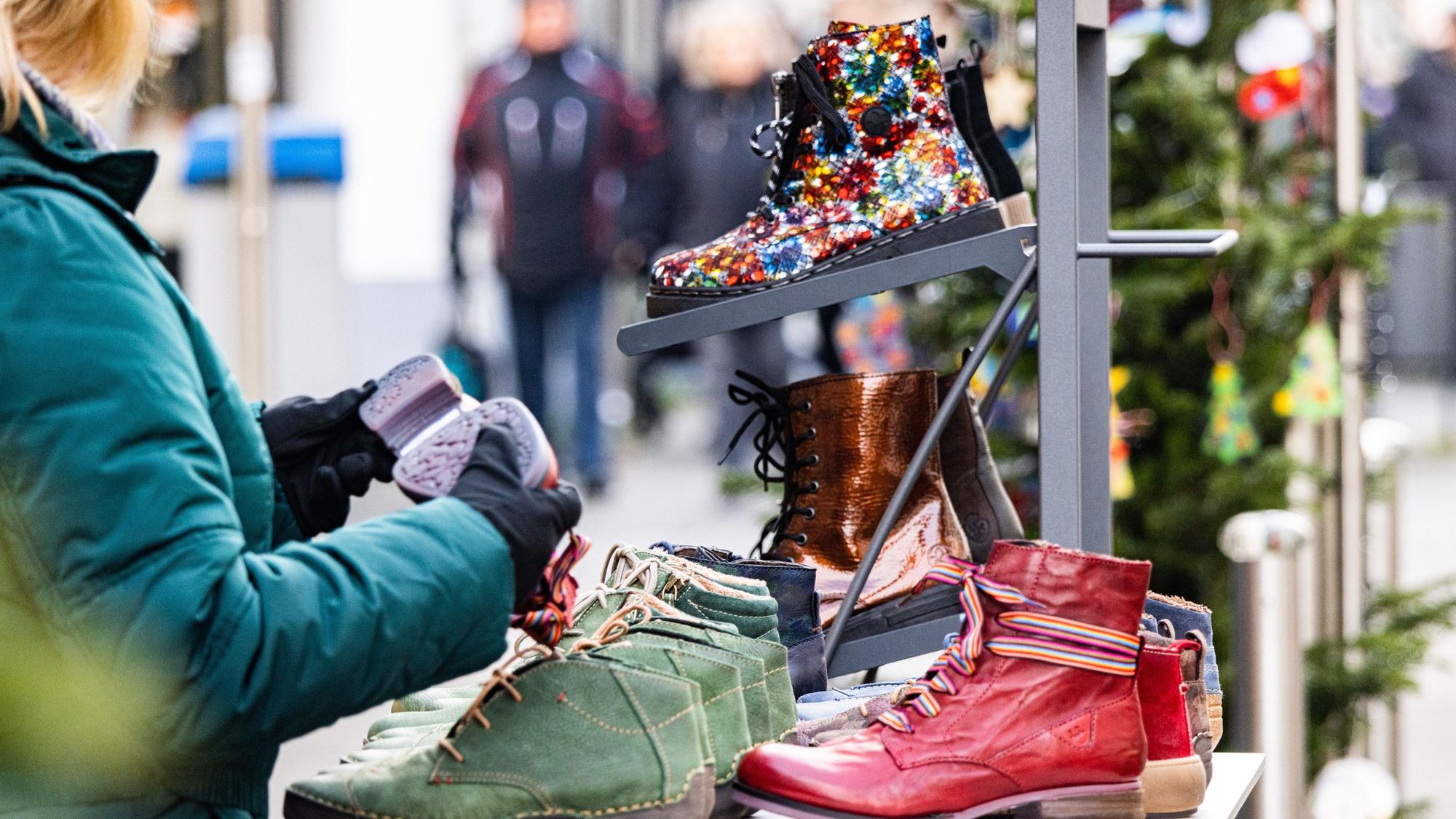 Eine Dame schaut sich an einem verlaufsoffenen Sonntag in Rheinbach Schuhe an.