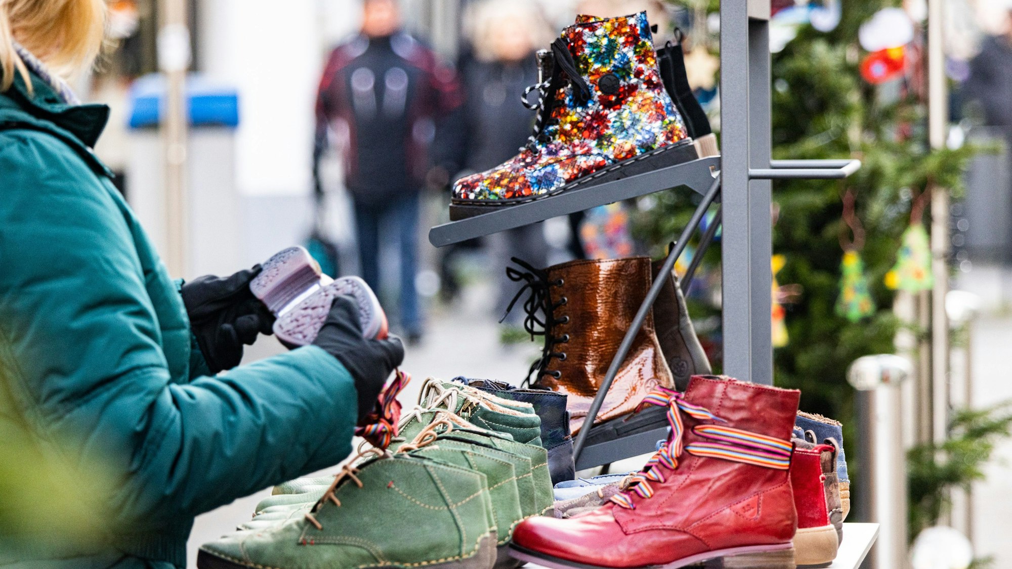 Eine Dame schaut sich an einem verlaufsoffenen Sonntag in Rheinbach Schuhe an.