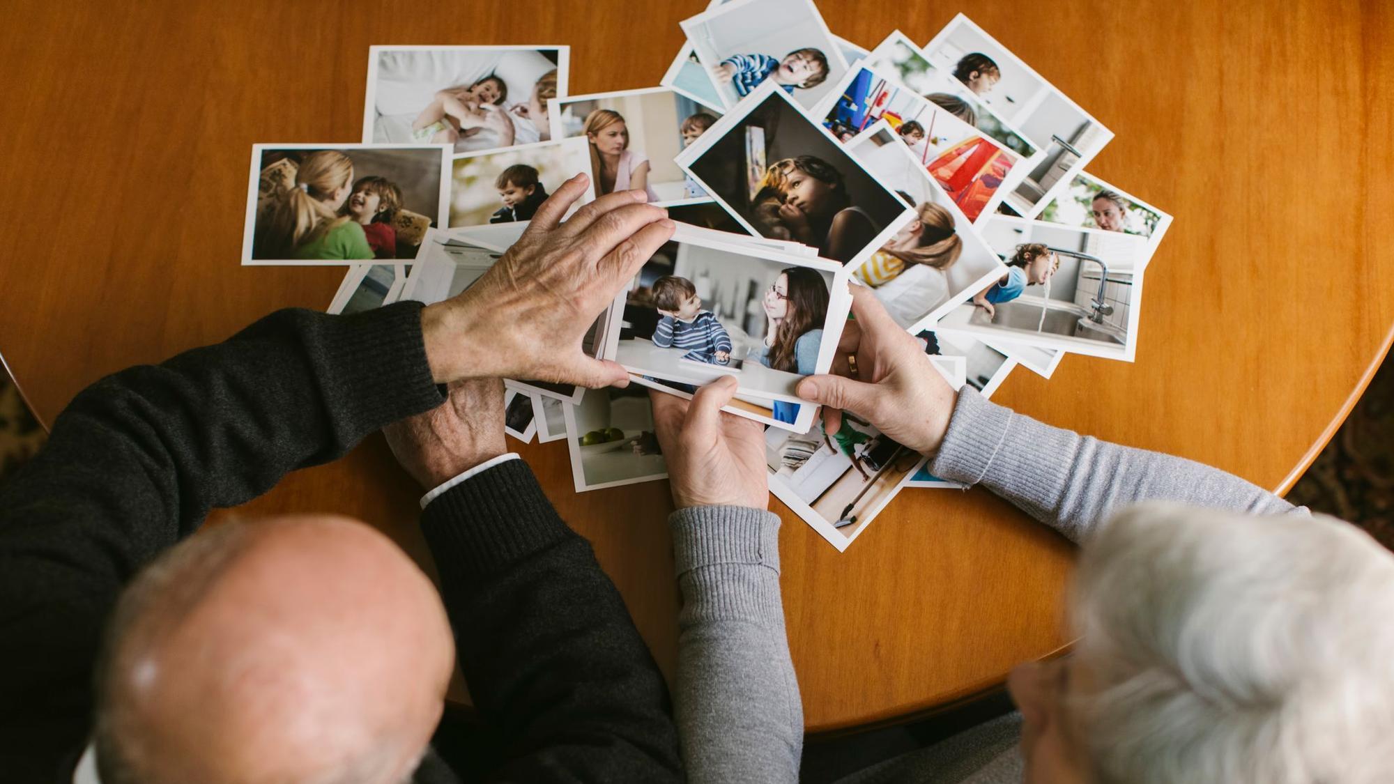 Ein älteres Paar schaut Fotos an.