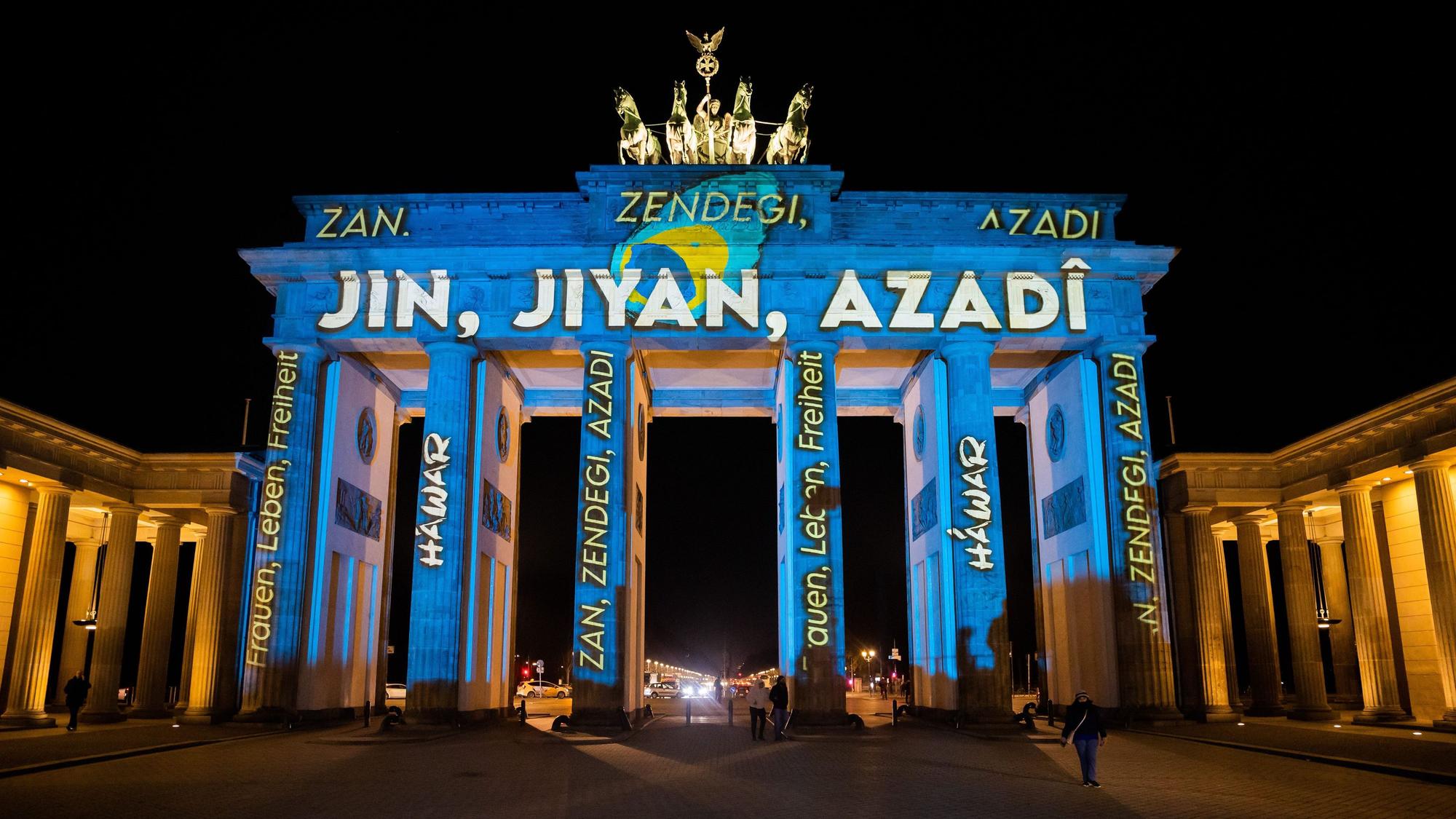 Das Brandenburger Tor wird bei einer Protestaktion für Solidarität mit den Protesten im Iran mit dem kurdischen Schriftzug „Jin, Jiyan, Azadi“ („Frau, Leben, Freiheit“) angestrahlt.