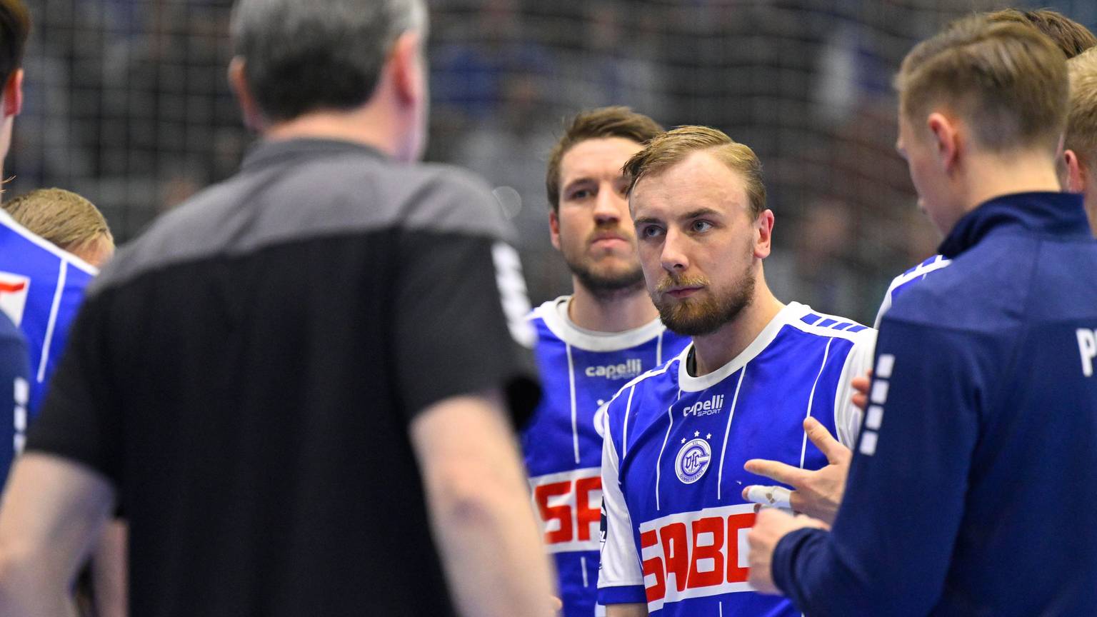 Einige Spieler des VfL Gummersbach stehen i Kreis zusammen, in der Mitte gut zu sehen ist Lukas Blohme.