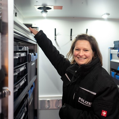 Die Brandermittlerin Jessica Scheer-Thielen steht in dem neuen Brandmobil und greift in ein Regal.