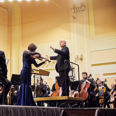 Die Philharmonie spielt auf einer Bühne.