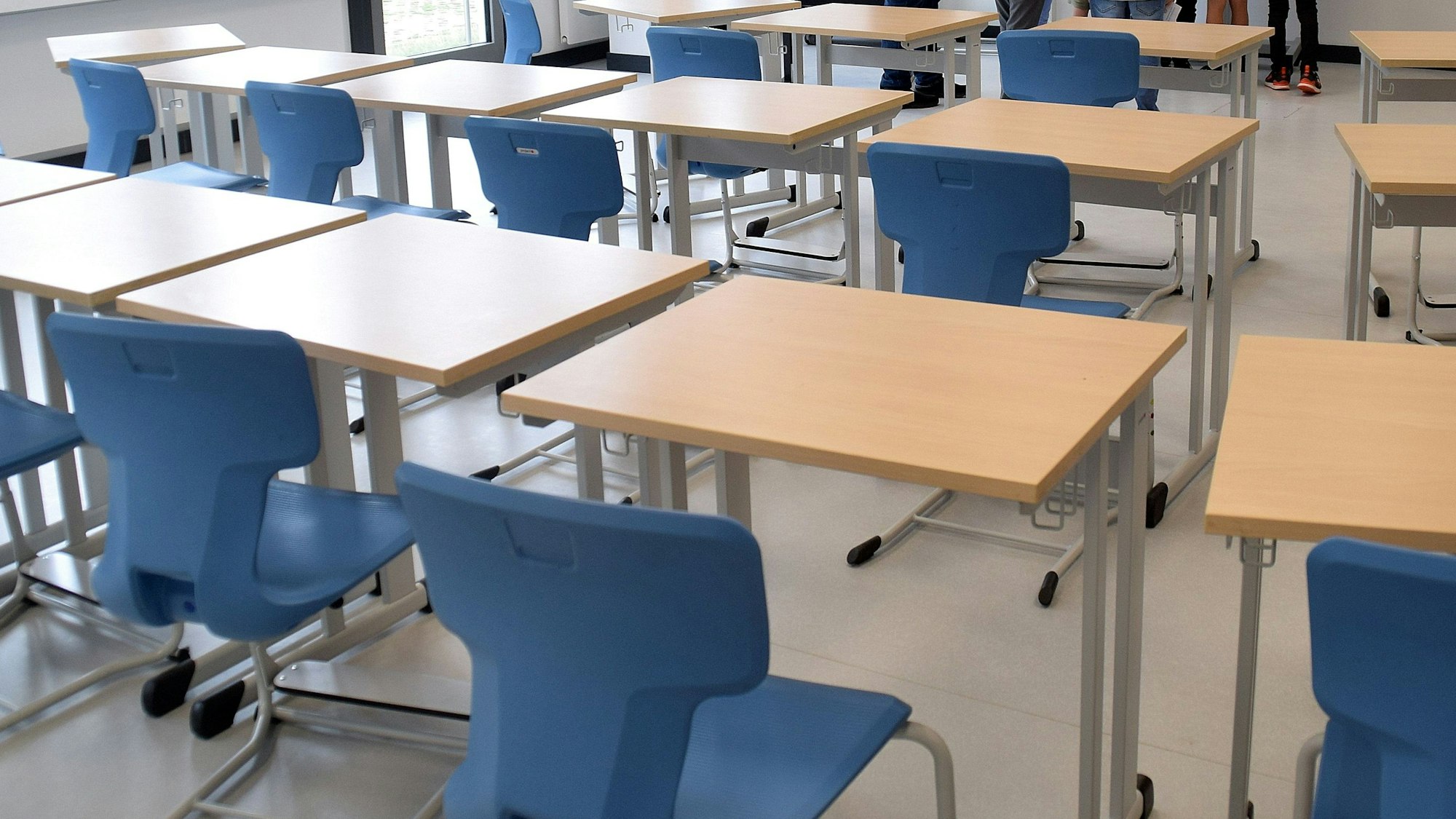 Einzeltische und Stühle stehen in einem Musterklassenzimmer.