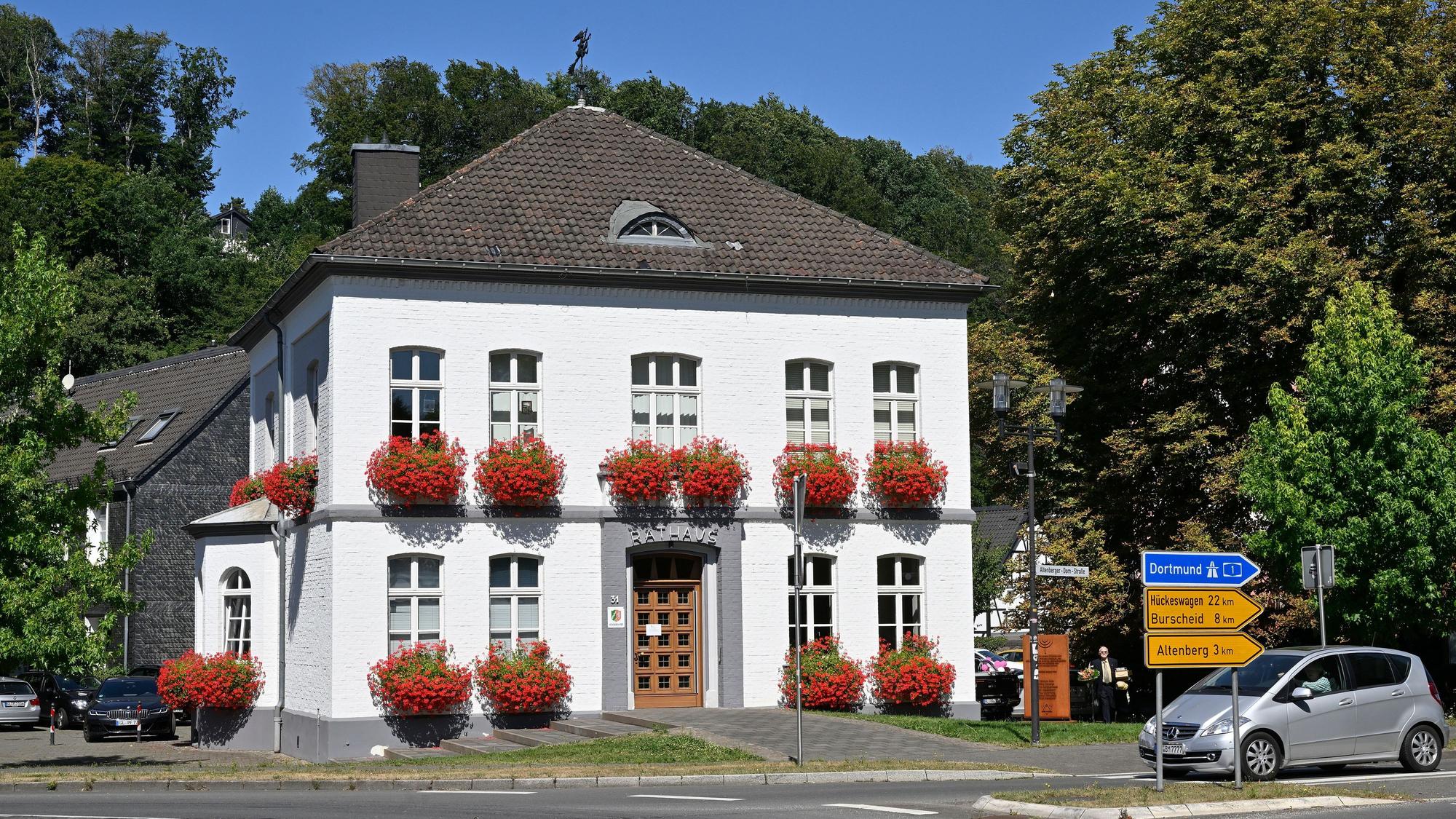 Hinter dem Odenthaler Rathaus stehen Bäume.