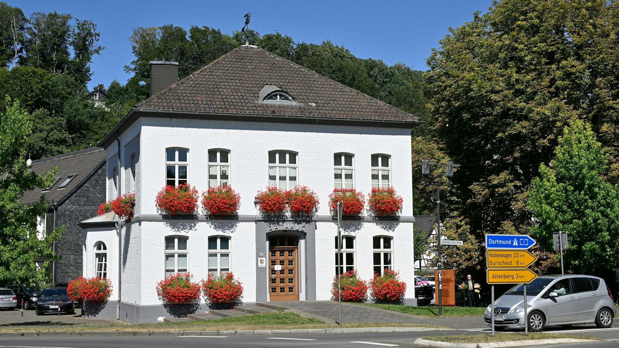 Hinter dem Odenthaler Rathaus stehen Bäume.