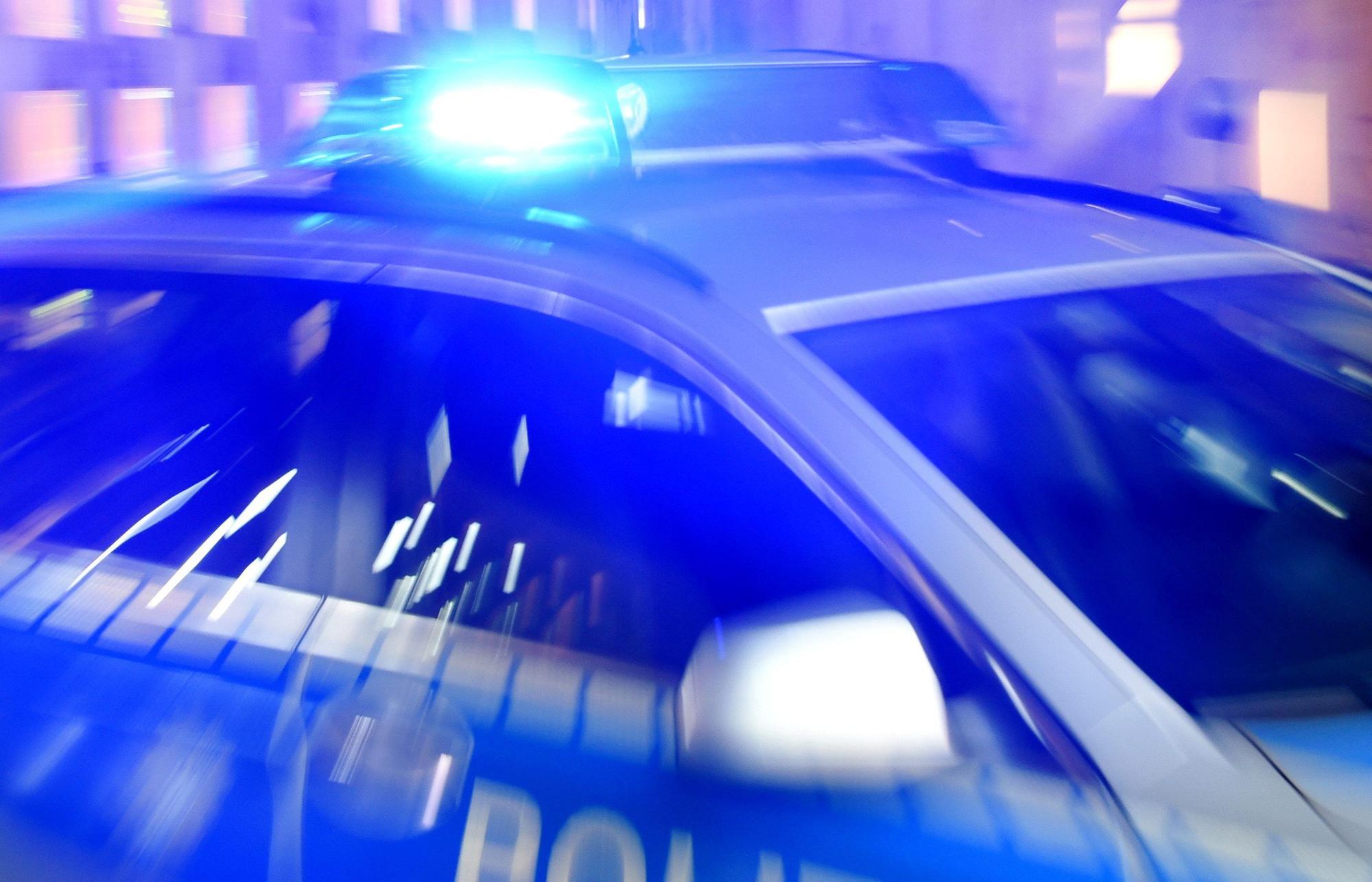 Ein Streifenwagen der Polizei steht mit eingeschaltetem Blaulicht auf der Straße.
