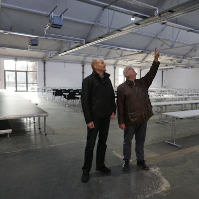 Zwei Männer, Jürgen Huthmacher (l.) und Christoph Stolzenberger, schauen sich das Dach der Veranstaltungshalle an.