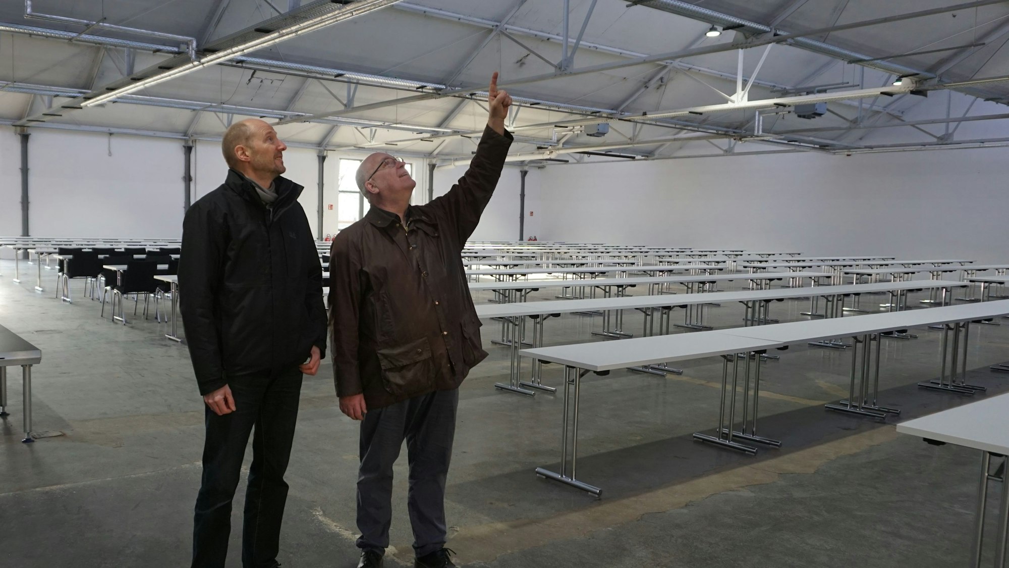 Zwei Männer, Jürgen Huthmacher (l.) und Christoph Stolzenberger, schauen sich das Dach der Veranstaltungshalle an.