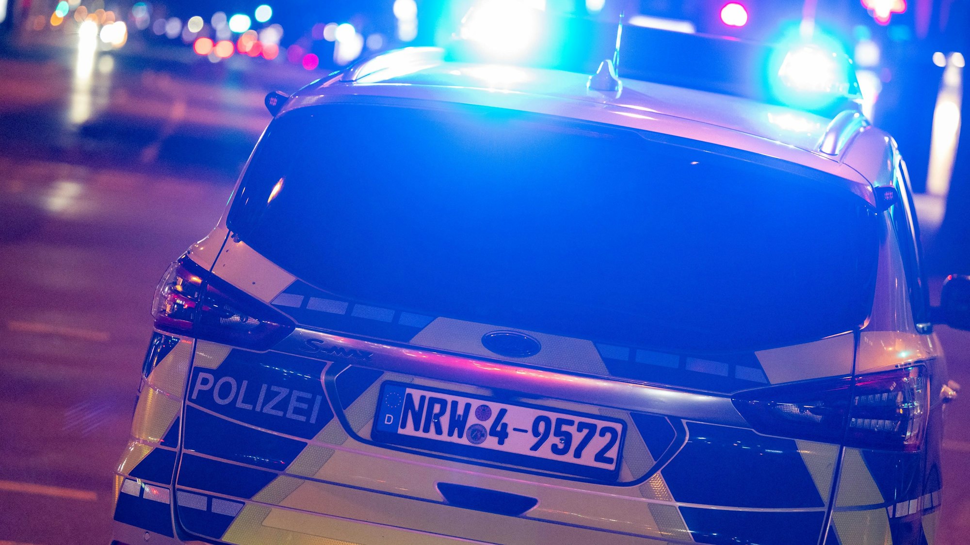 Ein Polizeiauto bei Nacht im Einsatz.