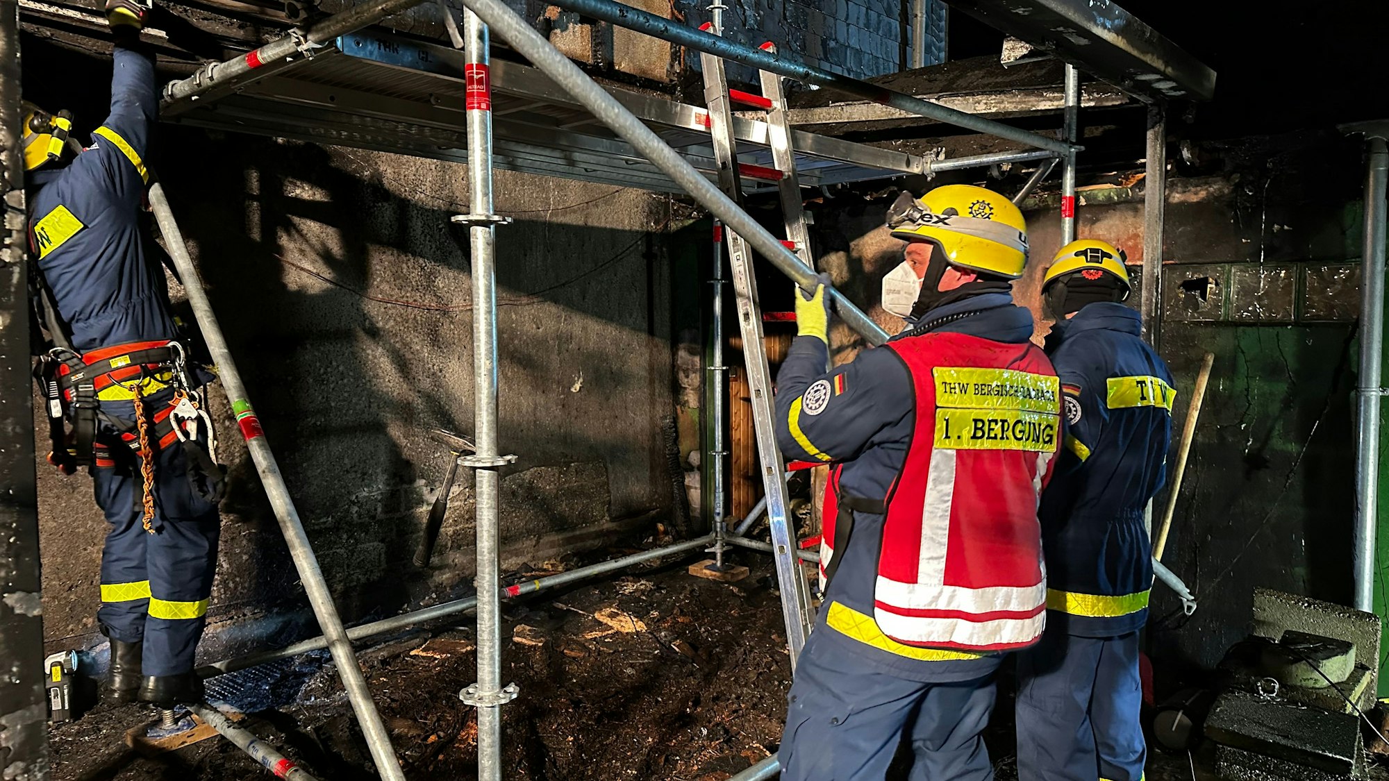 Einsatzkräfte des Technischen Hilfswerks bauen ein Gerüst auf.
