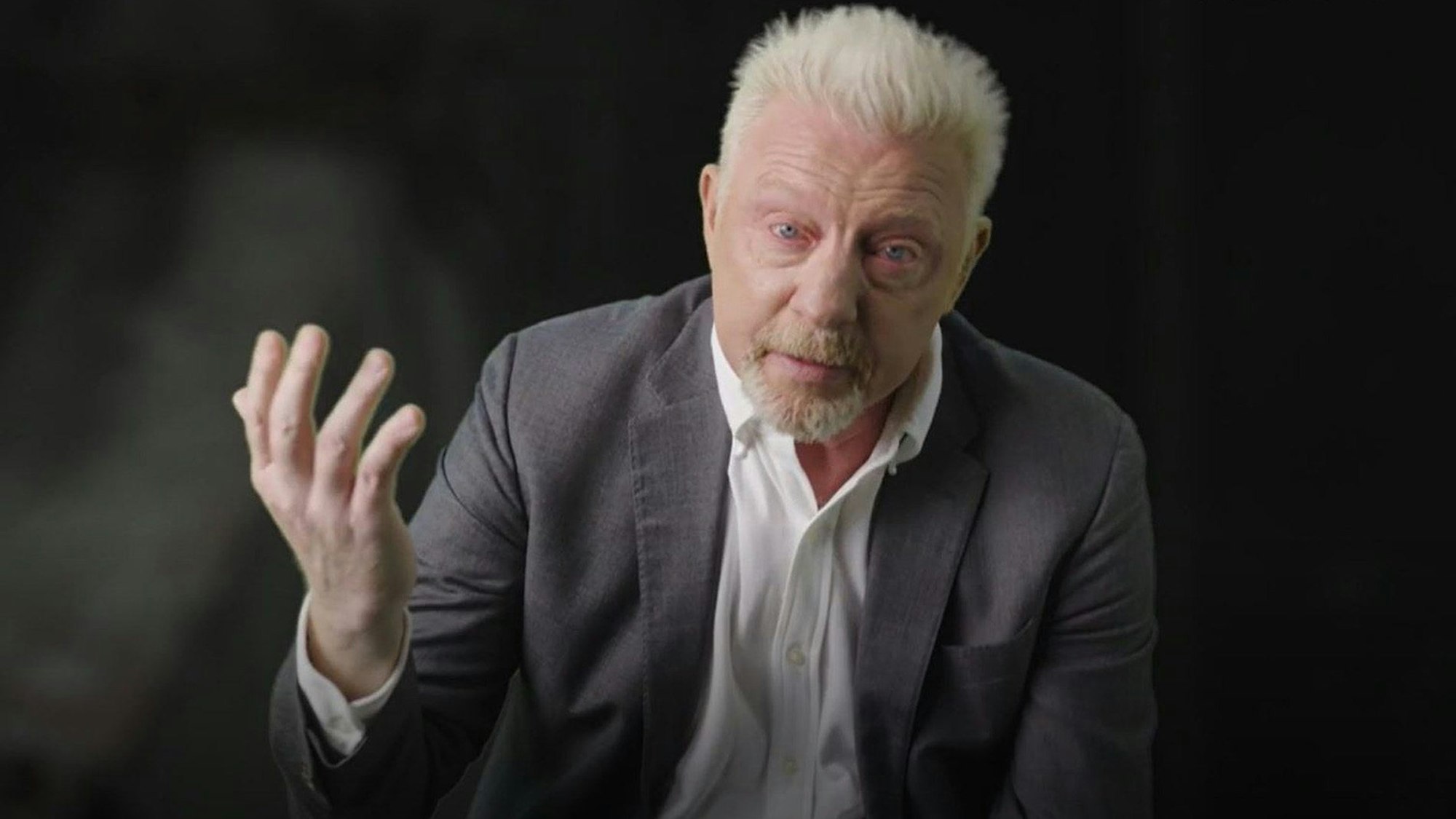 Boris Becker hebt beim Interview die Hand. Seine Augen sind rot unterlaufen.