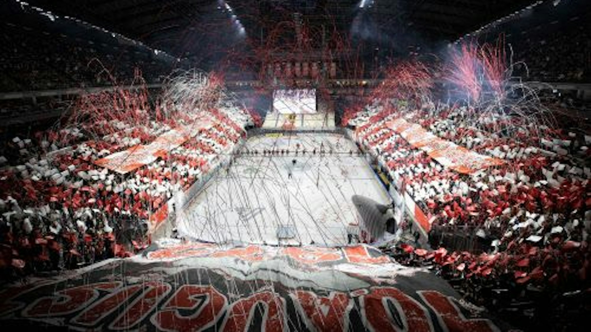 Die Eisfläche und die Tribüne werden von buntem Konfetti geschmückt.