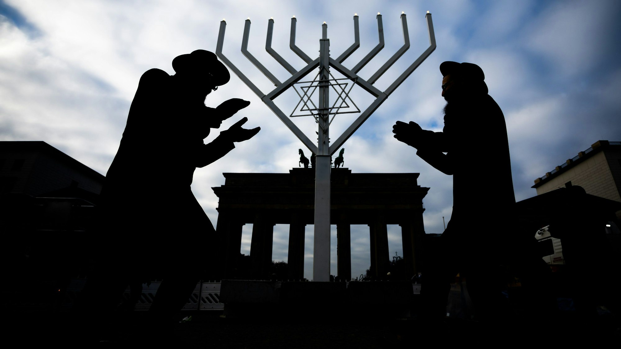 Rabbiner Yehuda Teichtal (l), Vorsitzender des Chabad Jüdischen Bildungszentrums, und Rabbiner Shmuel Segal, Programmdirektor des Chabad Jüdischen Bildungszentrums, tanzen bei der Einweihung des Chanukka-Leuchters vor dem Brandenburger Tor.