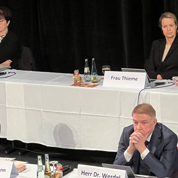 Landrat Stephan Santelmann und Kreisdirektor Dr. Erik Werdel sitzen an einem Tisch mit weißem Tischtuch und Namensschildern.