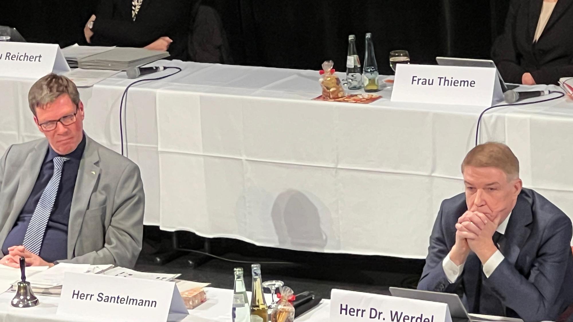 Landrat Stephan Santelmann und Kreisdirektor Dr. Erik Werdel sitzen an einem Tisch mit weißem Tischtuch und Namensschildern.