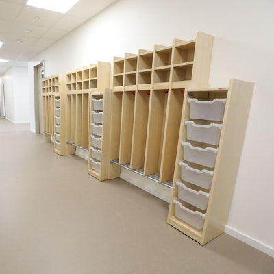 In einem langgezogenen Flur stehen auf der rechten Seite helle Holzmöbel mit kleinen Fächern für die Kleidung der Kindergartenkinder. Noch sind sie leer.