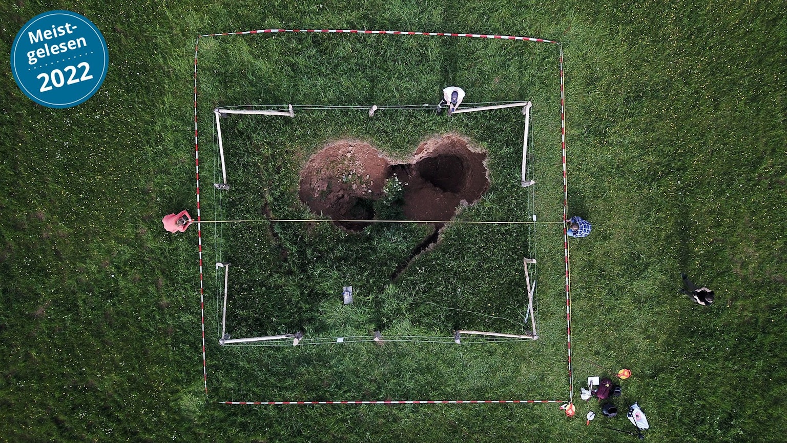 Ein unheimliches Loch mitten auf der Wiese: Drohnenbilder lassen einen herzförmigen Einsturzkrater erkennen.
