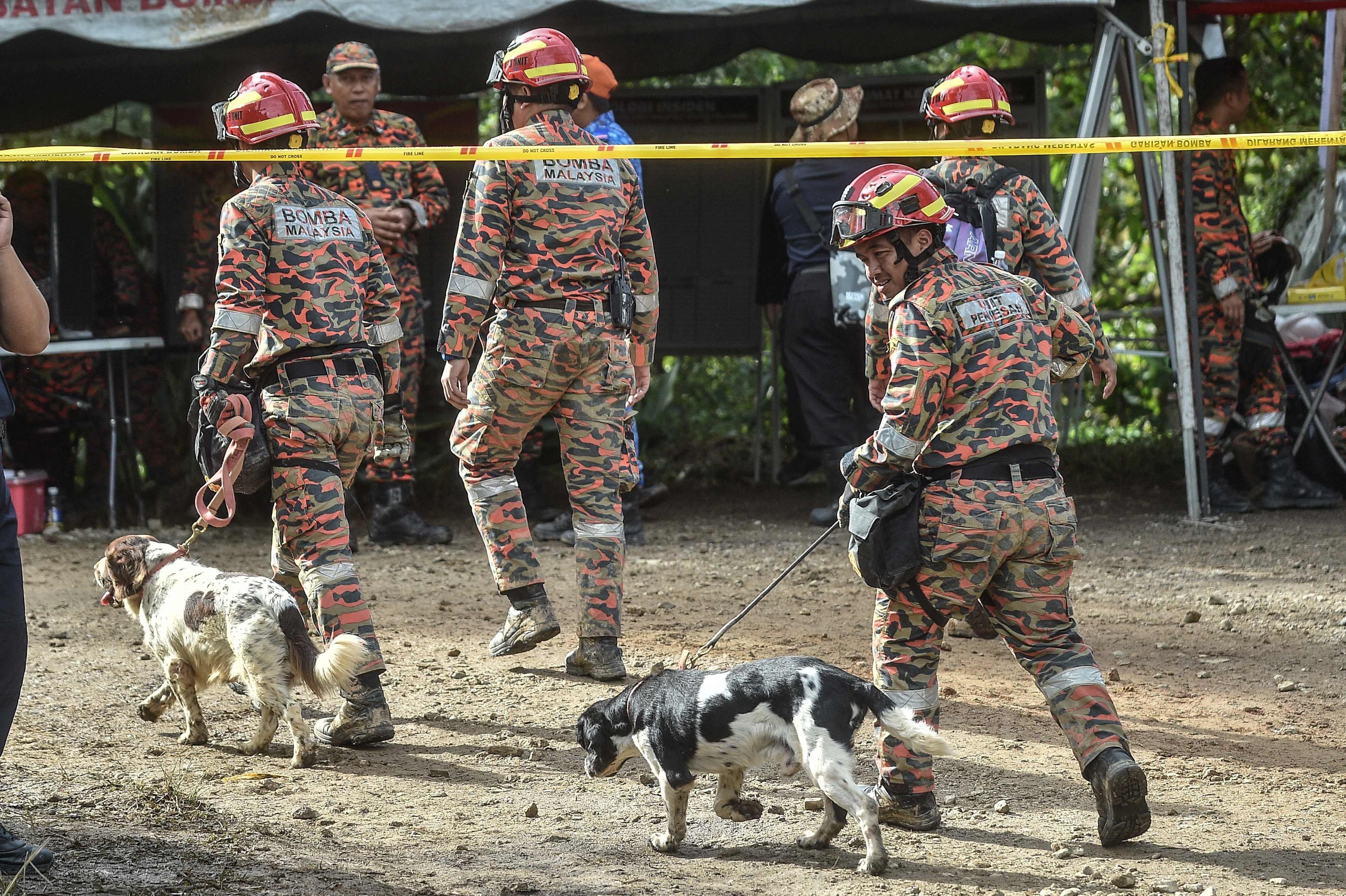 Rettungskräfte suchen mit Spürhunden an der Stelle des tödlichen Erdrutsches nach Überlebenden in Batang Kali.