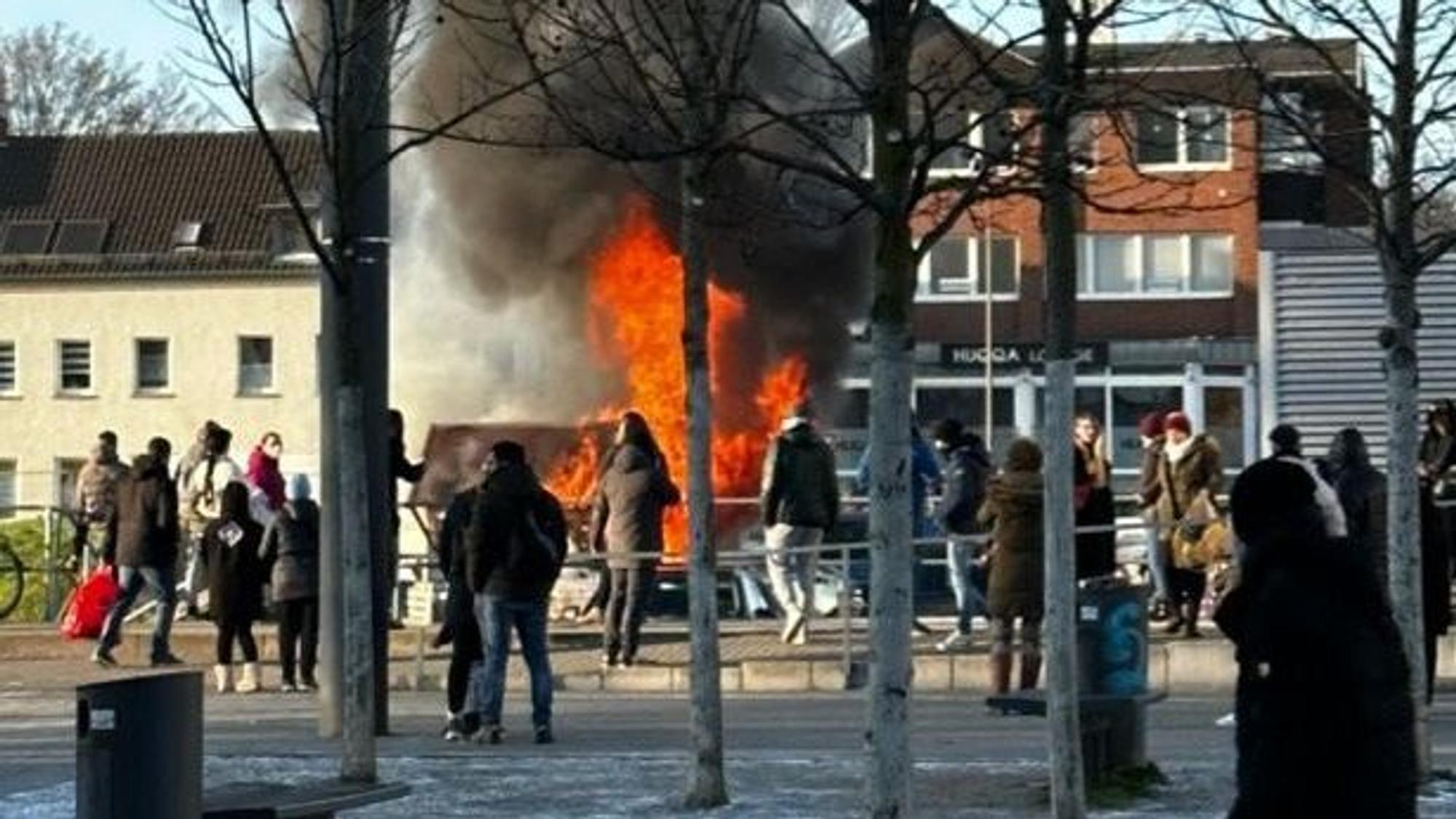 Offene Flammen schlagen aus einem Holzhaus, schwarzer Qualm steigt auf.