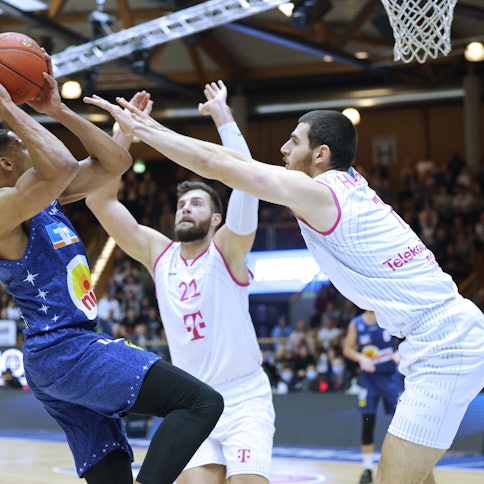 Bonns Leon Kratzer (M.) und Sebastian Herrera (r.) attackieren Jaren Lewis.
