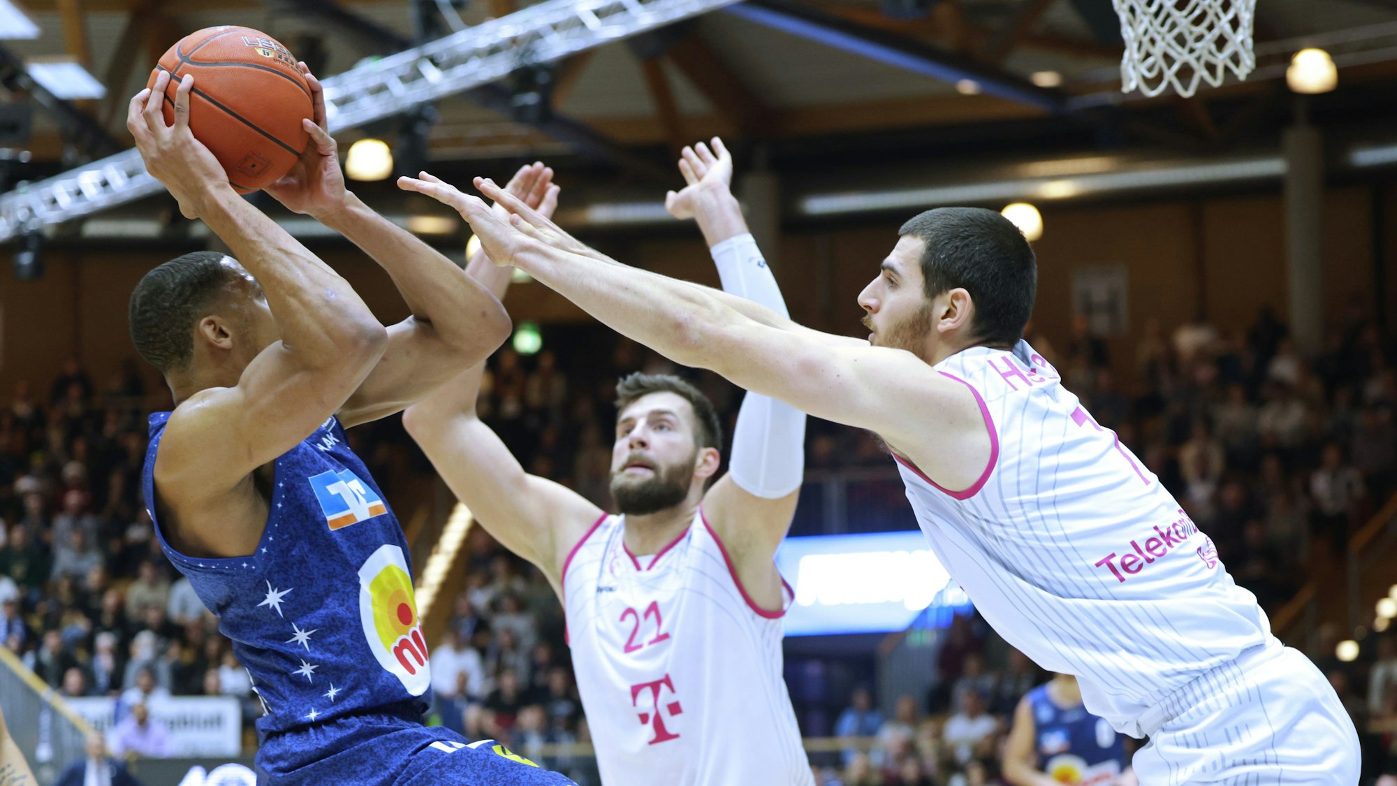 Bonns Leon Kratzer (M.) und Sebastian Herrera (r.) attackieren Jaren Lewis.