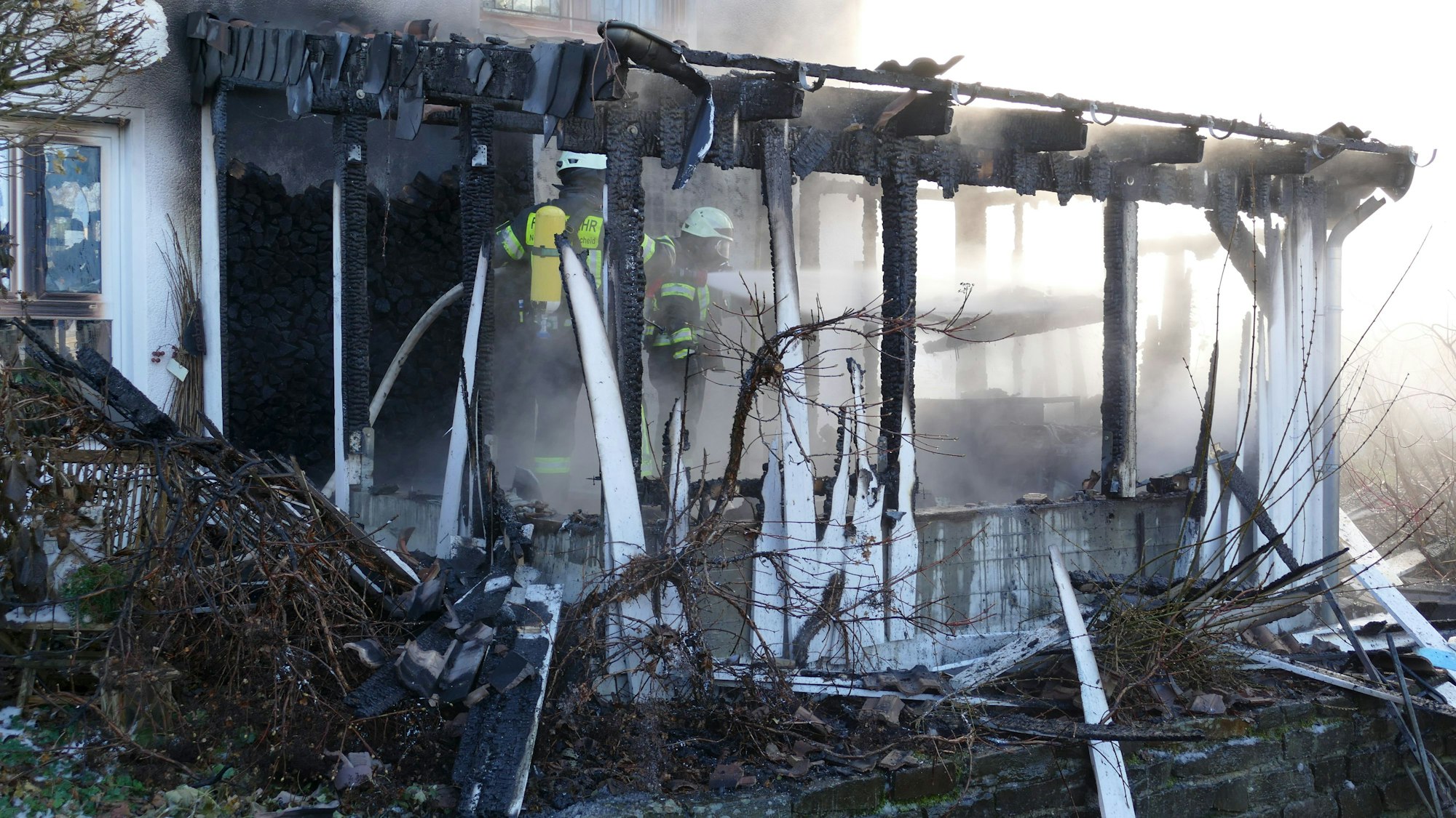 Der hölzerne Anbau eines Wohnhauses brennt in Neunkirchen-Seelscheid.